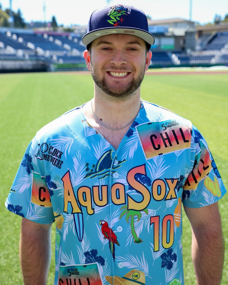 Baseball player in a colorful tropical-themed jersey with parrot and palm tree designs.