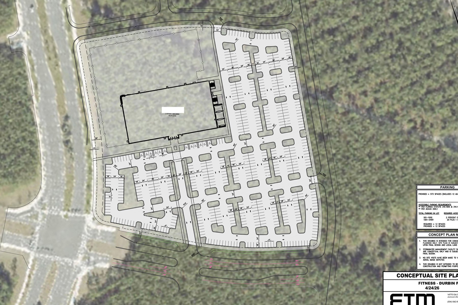 Aerial conceptual site plan showing a large rectangular building surrounded by parking lots and wooded borders.