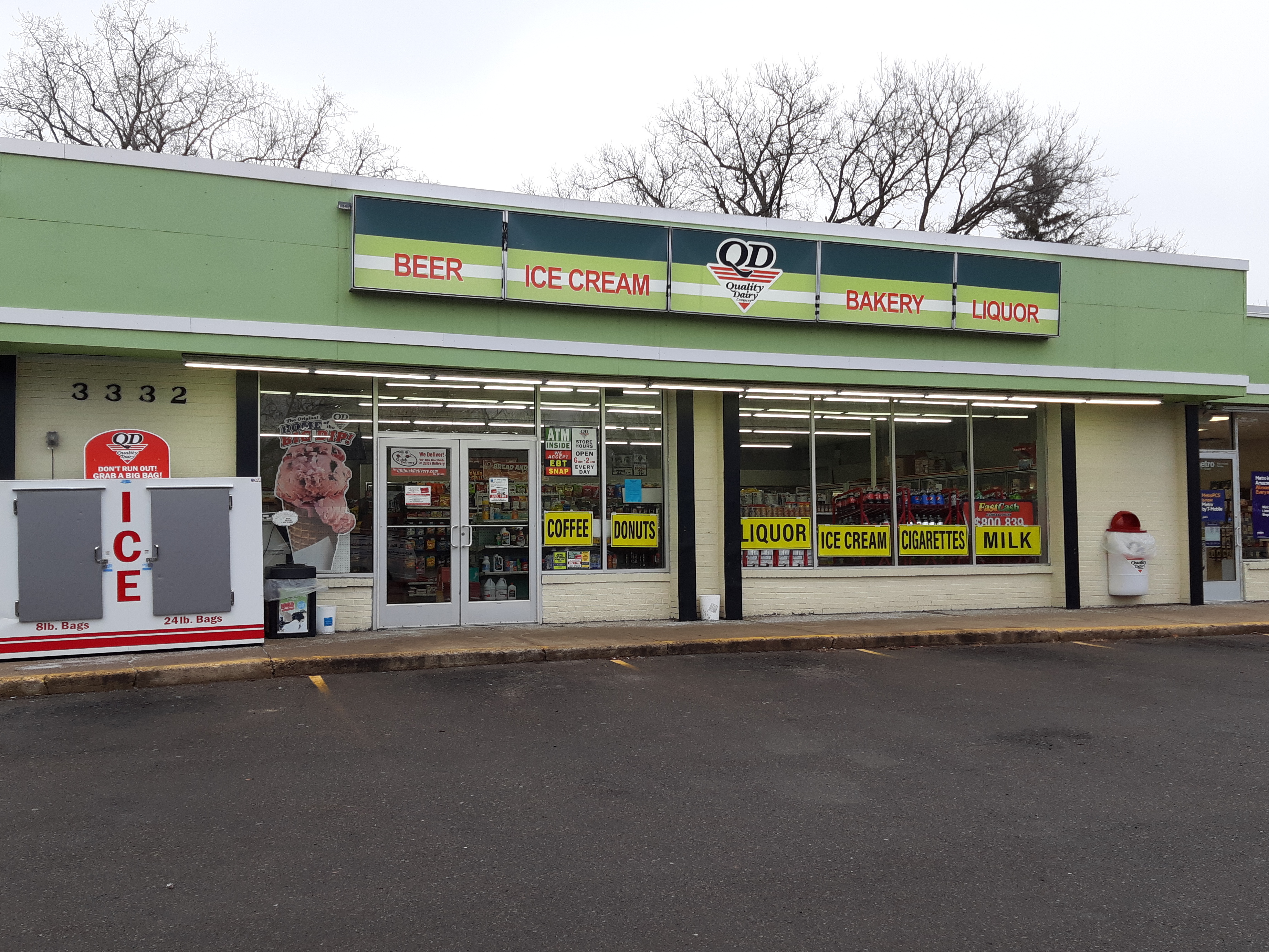 Exterior of a Quality Dairy store with signage advertising bakery and donuts.