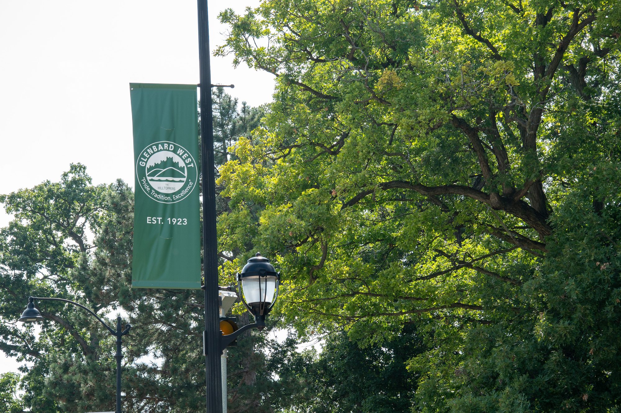 Green Glenbard West campus banner marked Established 1923 on a lamp post.