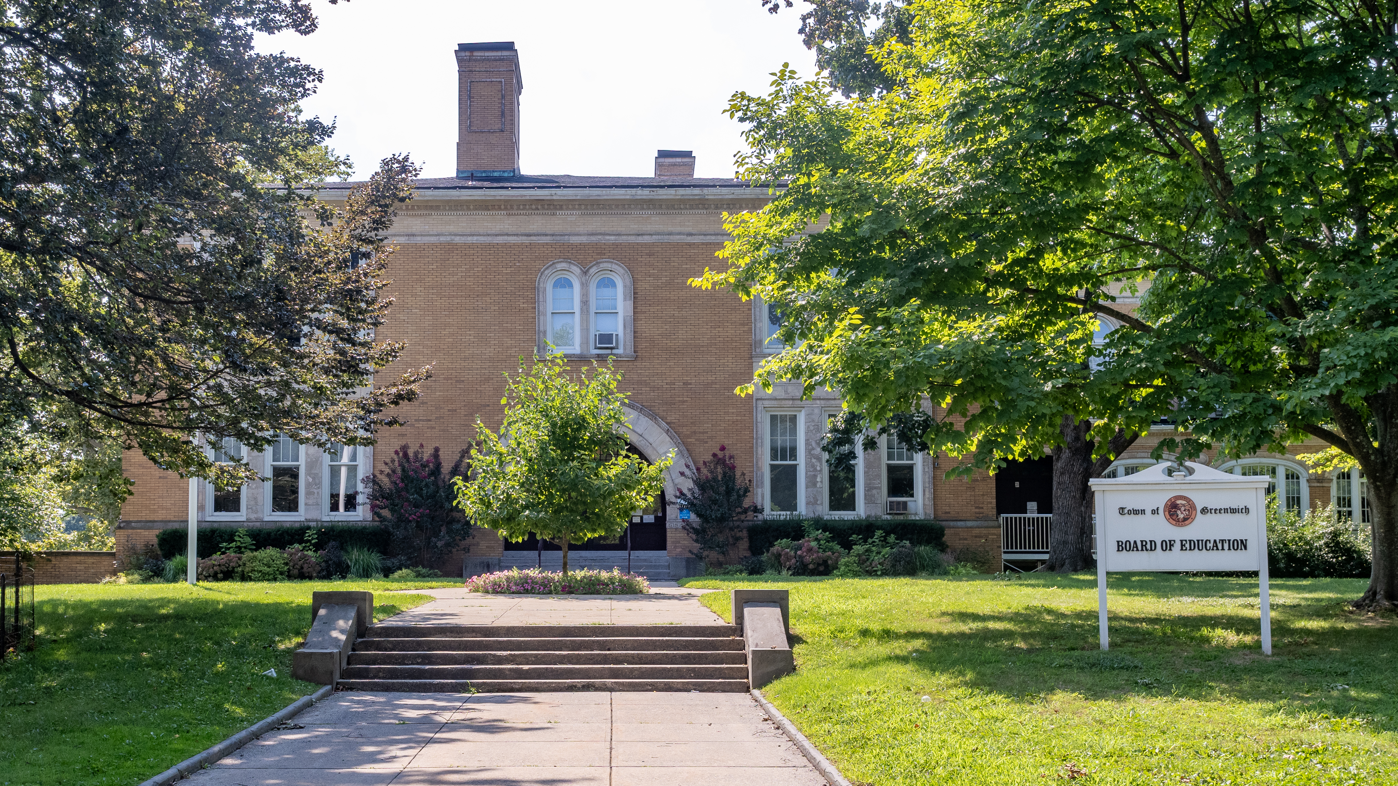 Two-story brick building with a Board of Education sign on the front lawn.