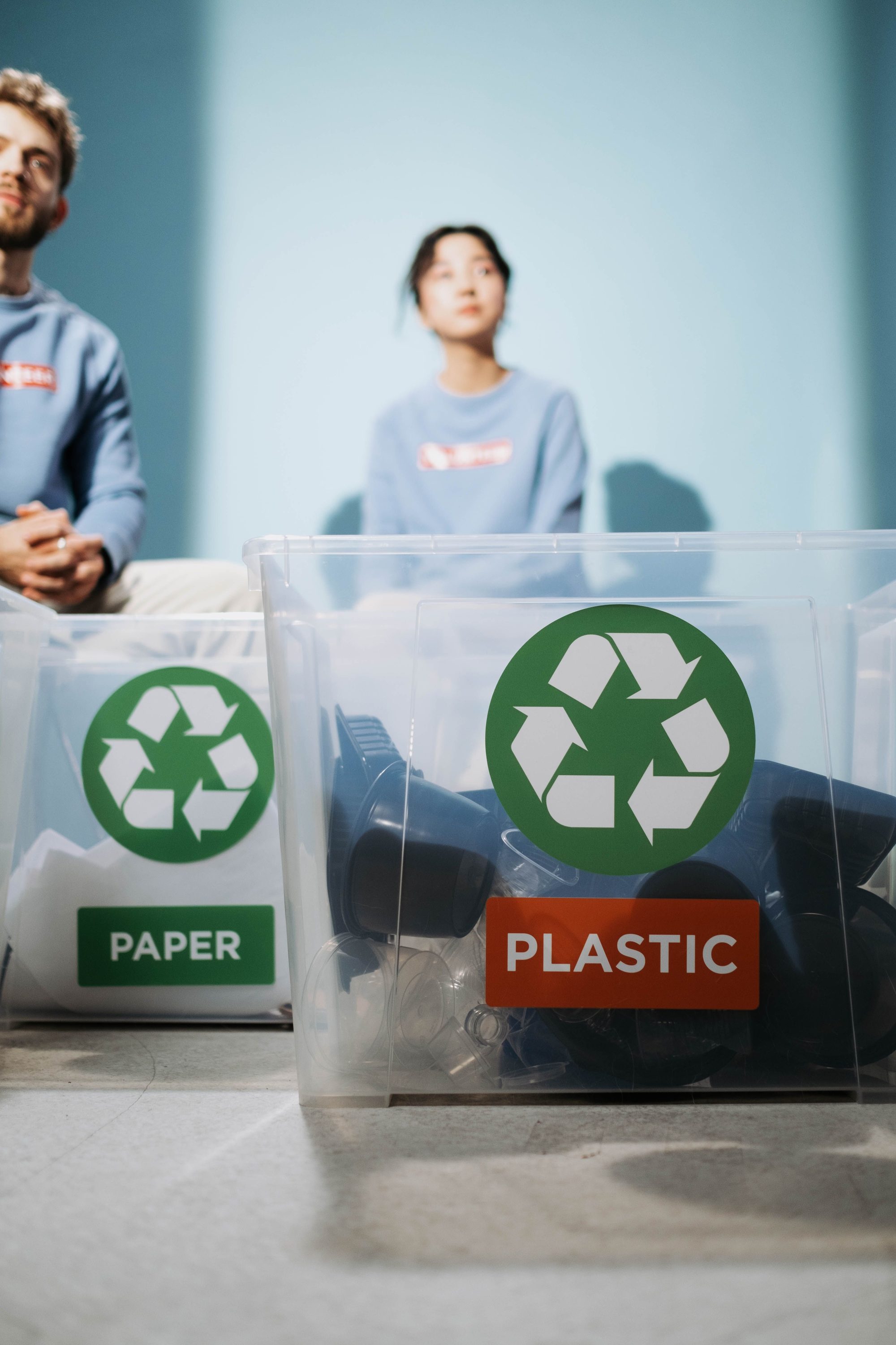 Two recycling bins labeled for paper and plastic materials for environmental conservation.