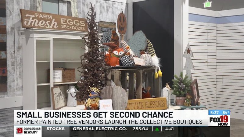 Decorated vendor booth with seasonal items, small Christmas tree, and farm-themed signs.
