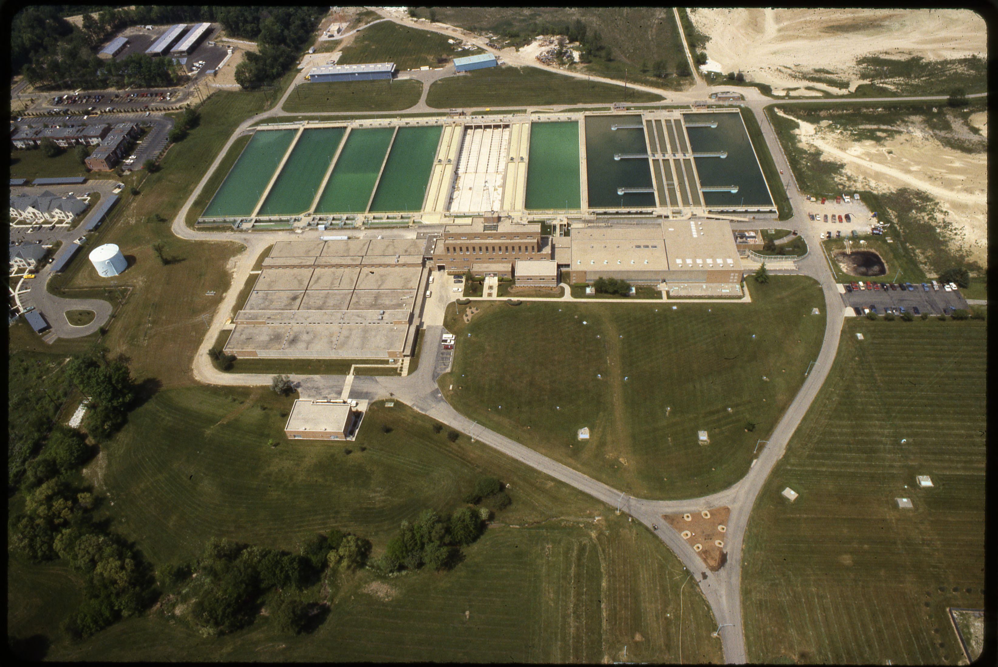 Aerial view of a large water treatment facility with rectangular basins and industrial buildings.