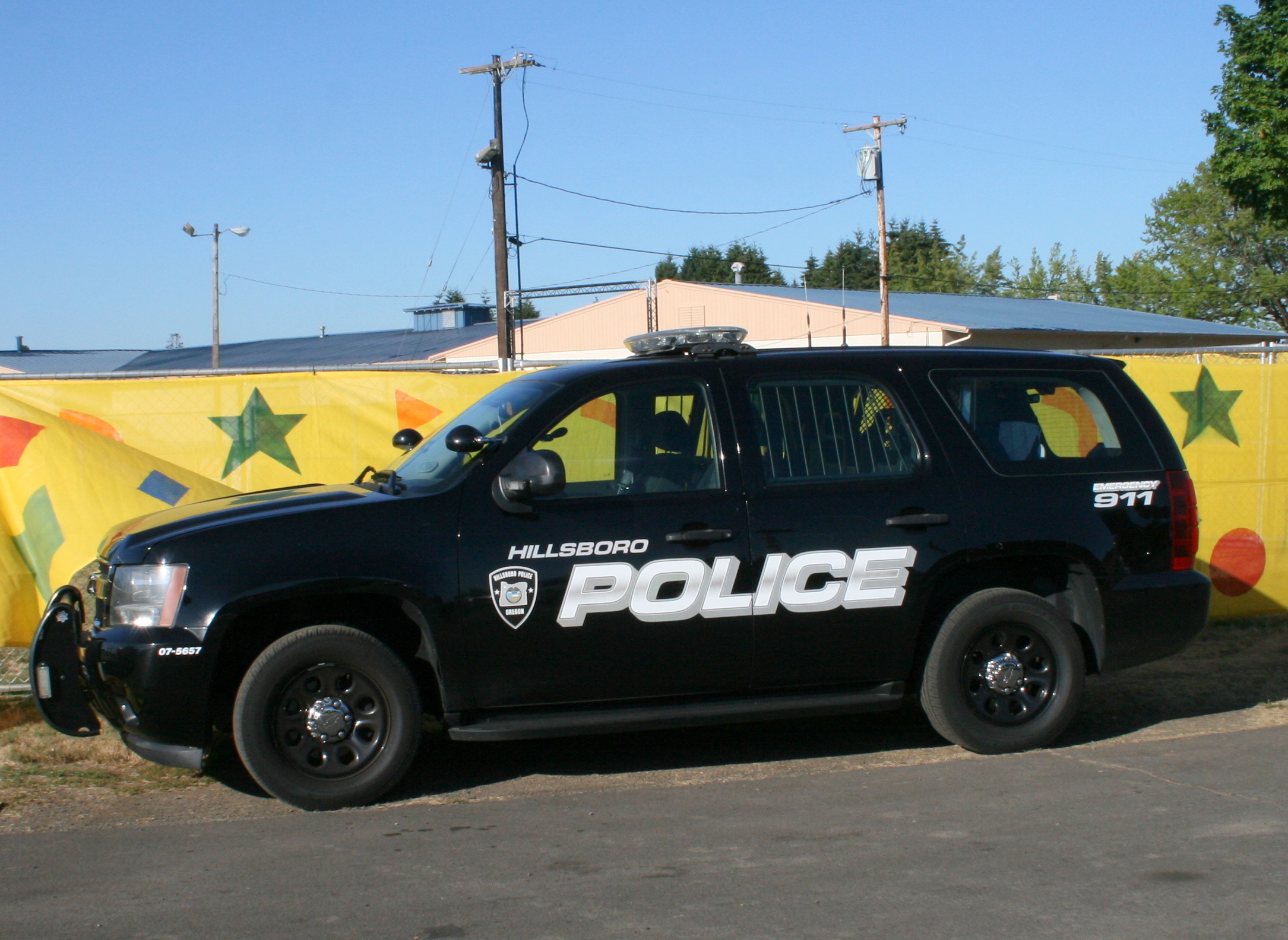 Black Hillsboro Police Department SUV parked in a lot with a colorful mural behind it.