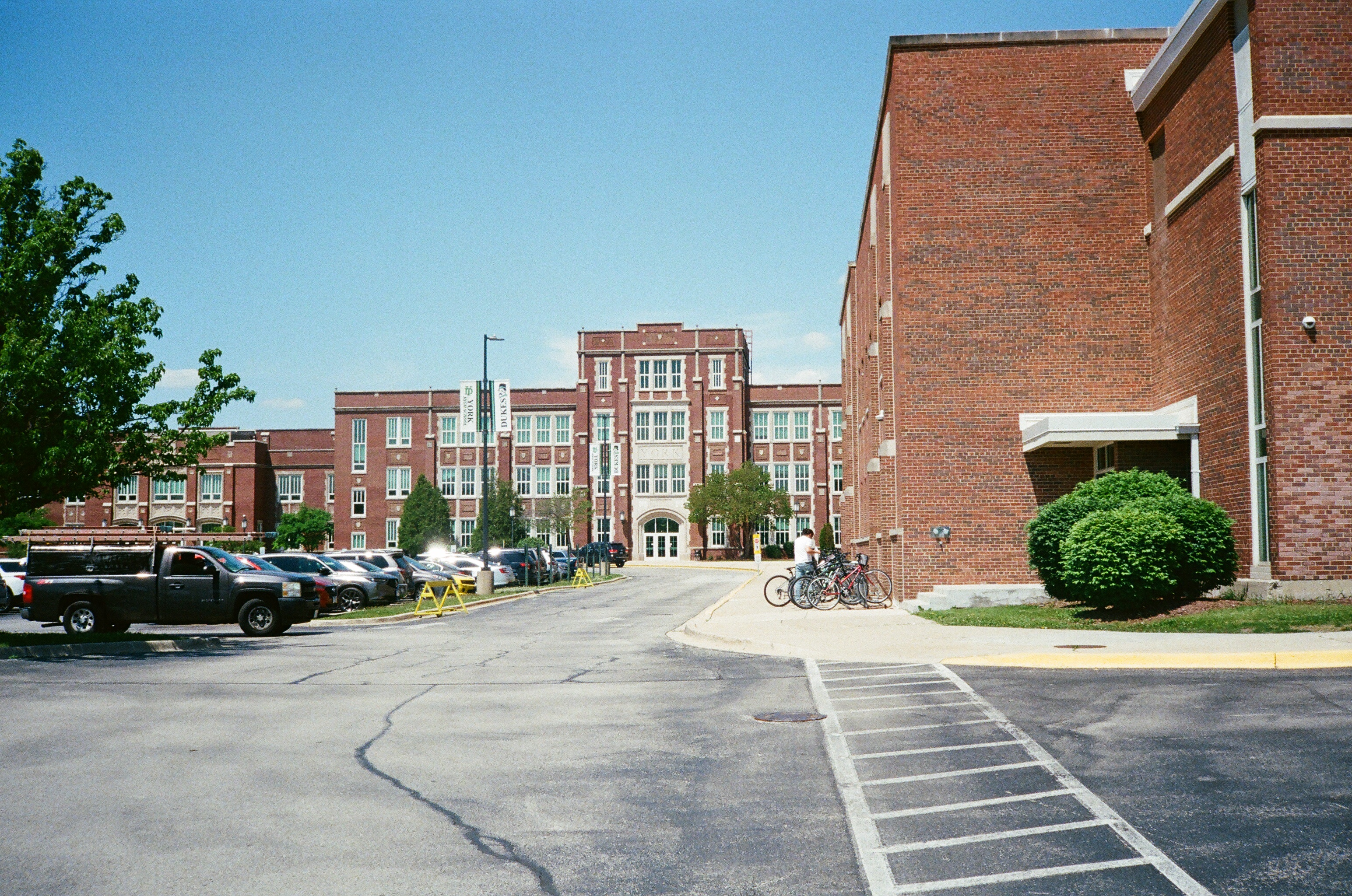 Exterior of a large red brick high school building on a sunny day.