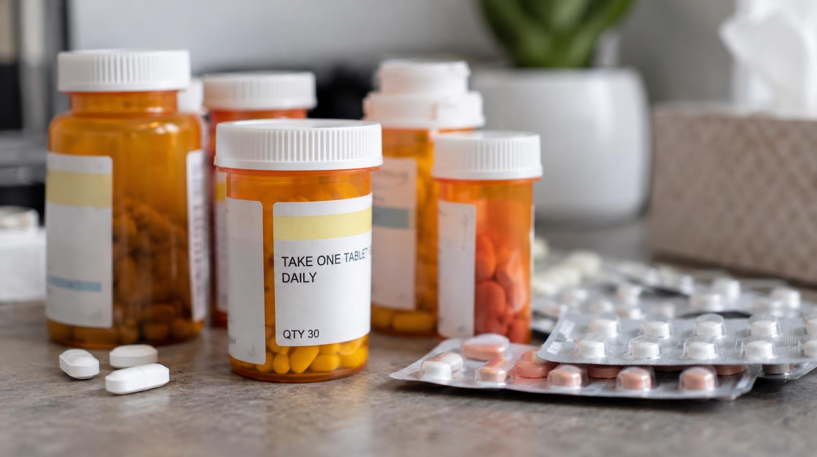 Assorted prescription pill bottles and blister packs on a flat surface.