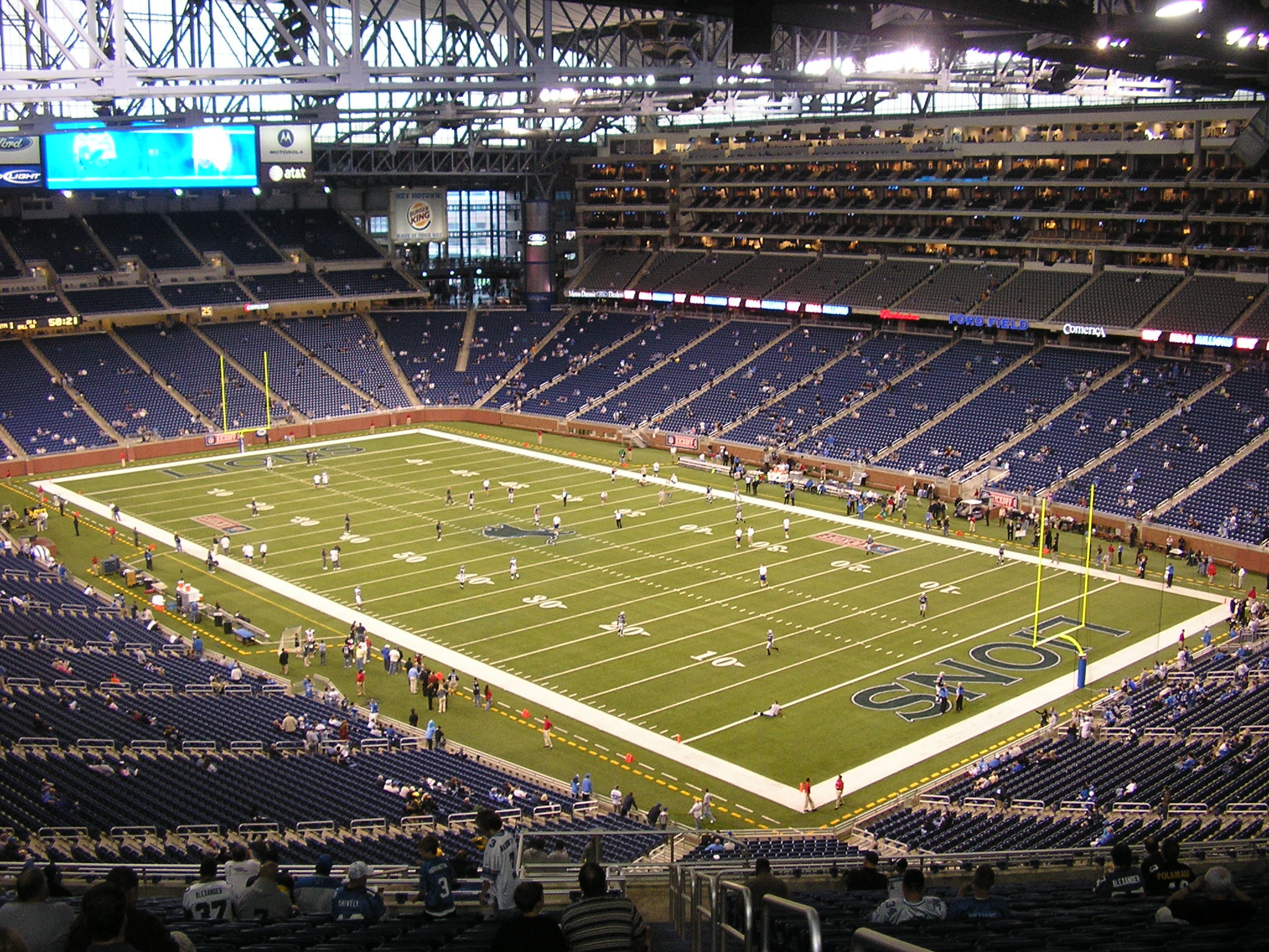 Inside Ford Field showing the football field, goalposts, and tiered seating bowl.