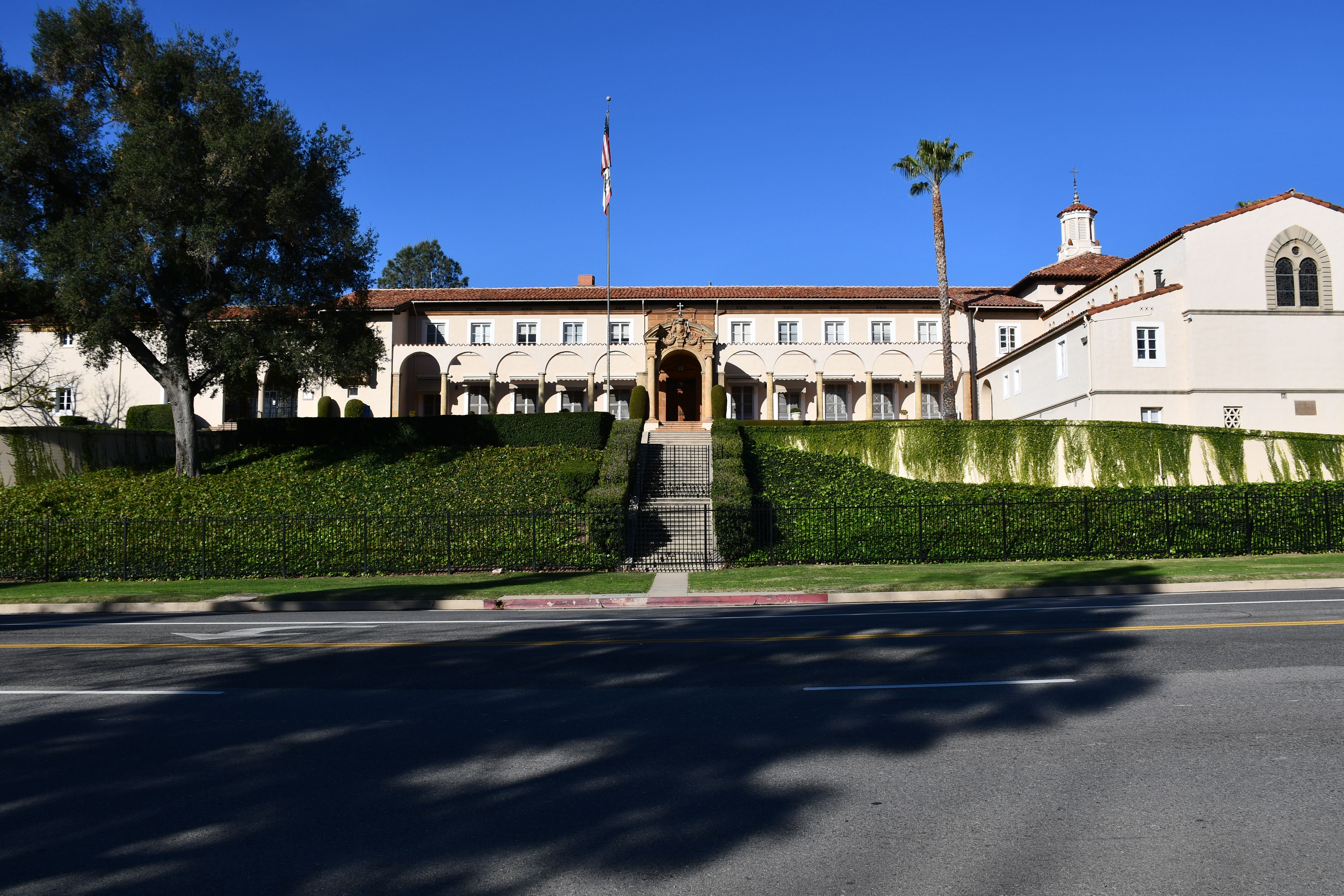 Spanish Colonial Revival school building with white stucco walls, red tile roof, and a palm tree.