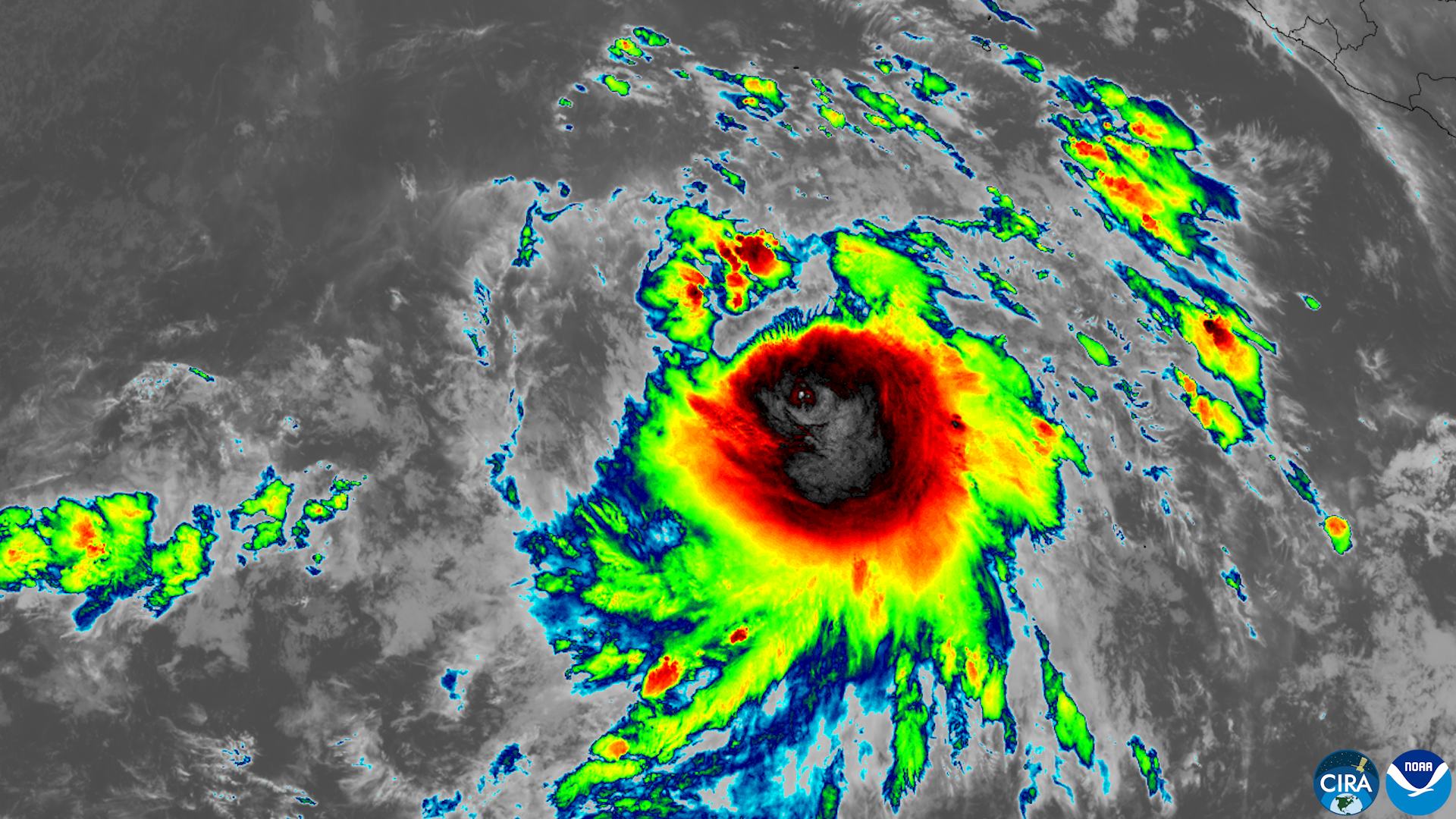 Enhanced infrared satellite image of a Pacific hurricane with a defined eye and colorized cloud bands.