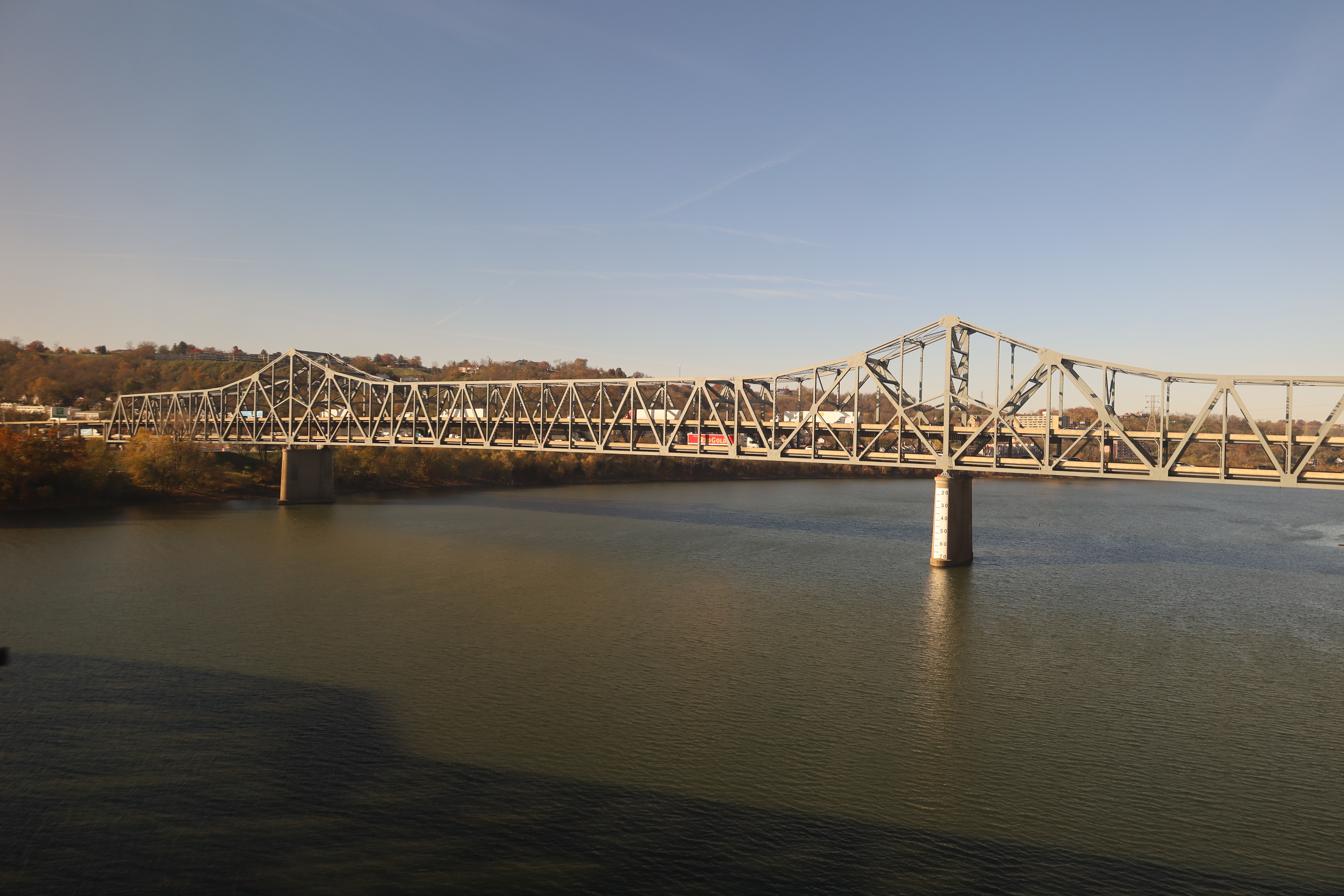 Steel cantilever truss bridge spanning a wide river under a clear blue sky.
