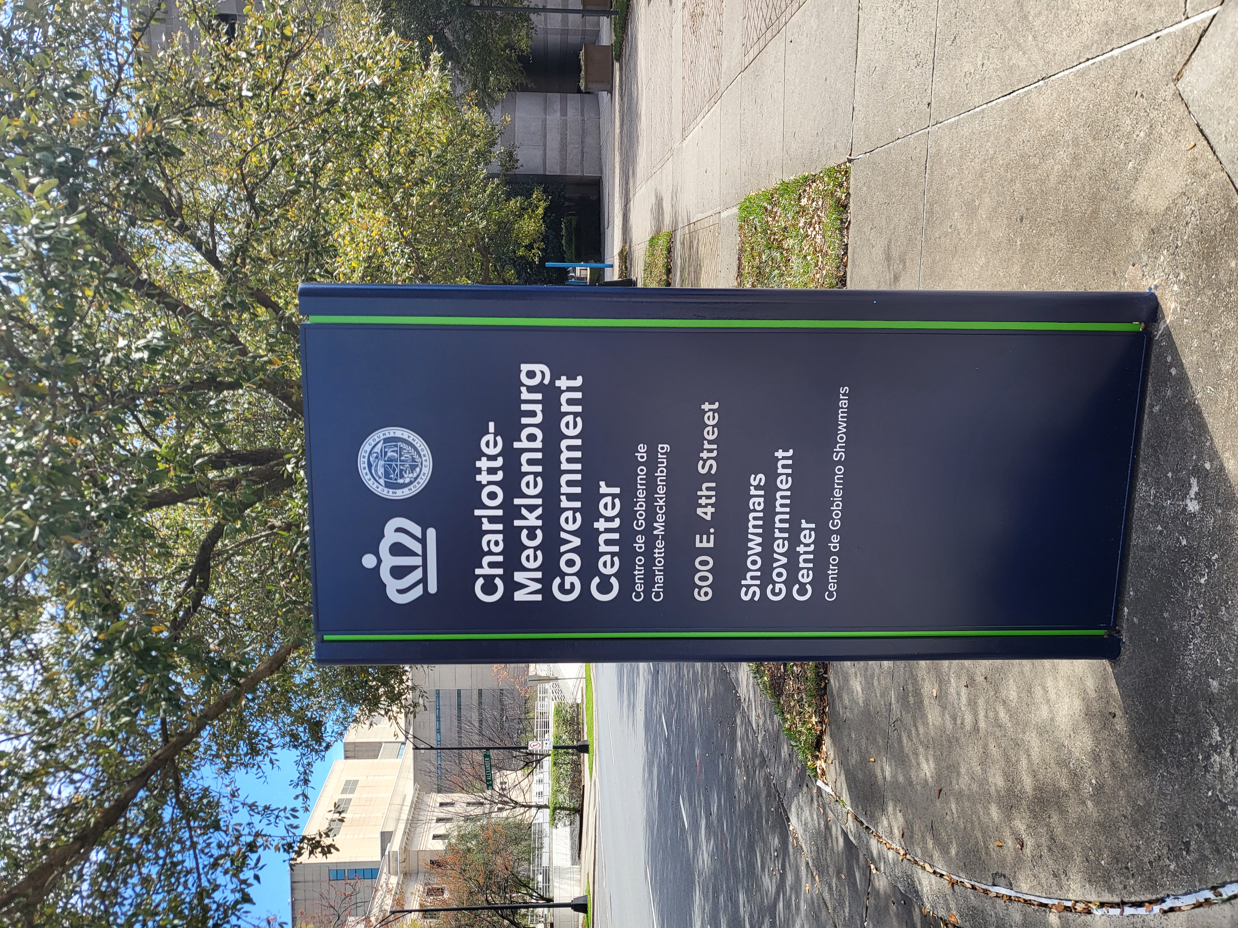 Monument sign for the Charlotte-Mecklenburg Government Center on a sidewalk.
