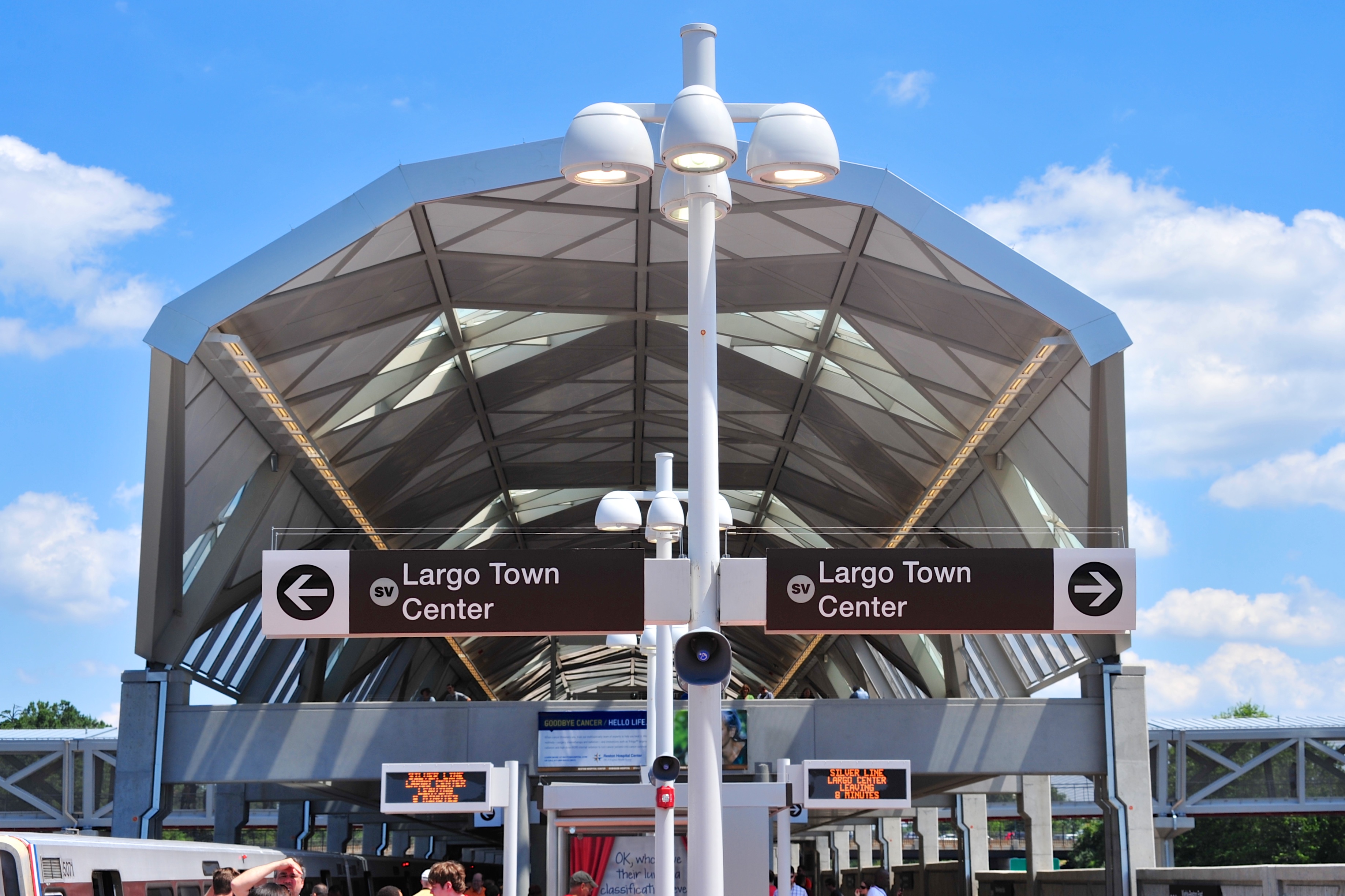 Wiehle-Reston East Metro station canopy with directional signs under a blue sky.