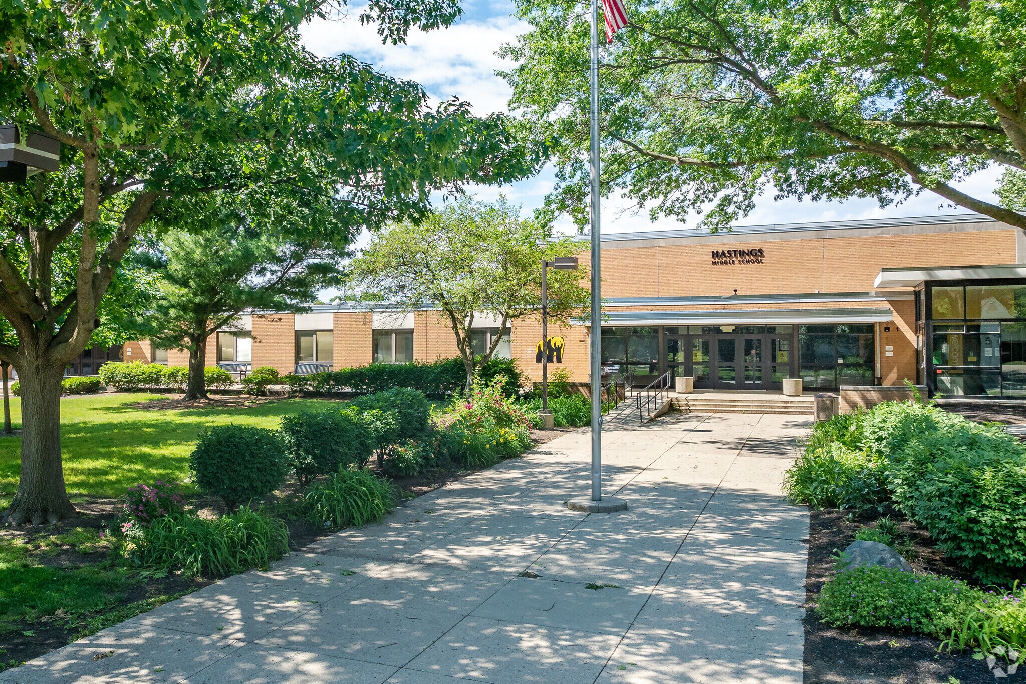 Front exterior of Hastings Middle School, a single-story brick building with a flagpole.