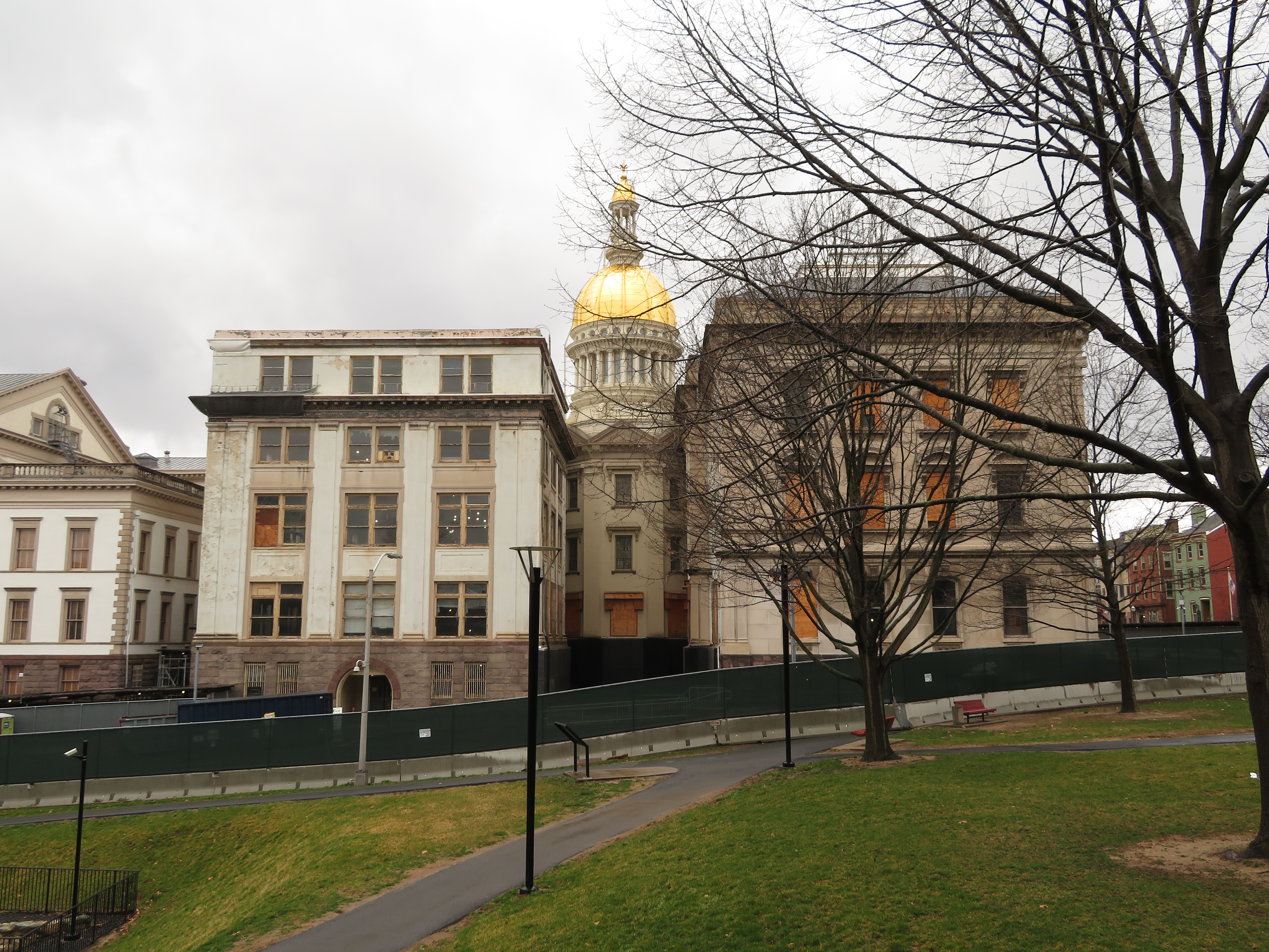 Exterior of the New Jersey State House with its gold dome on an overcast day.