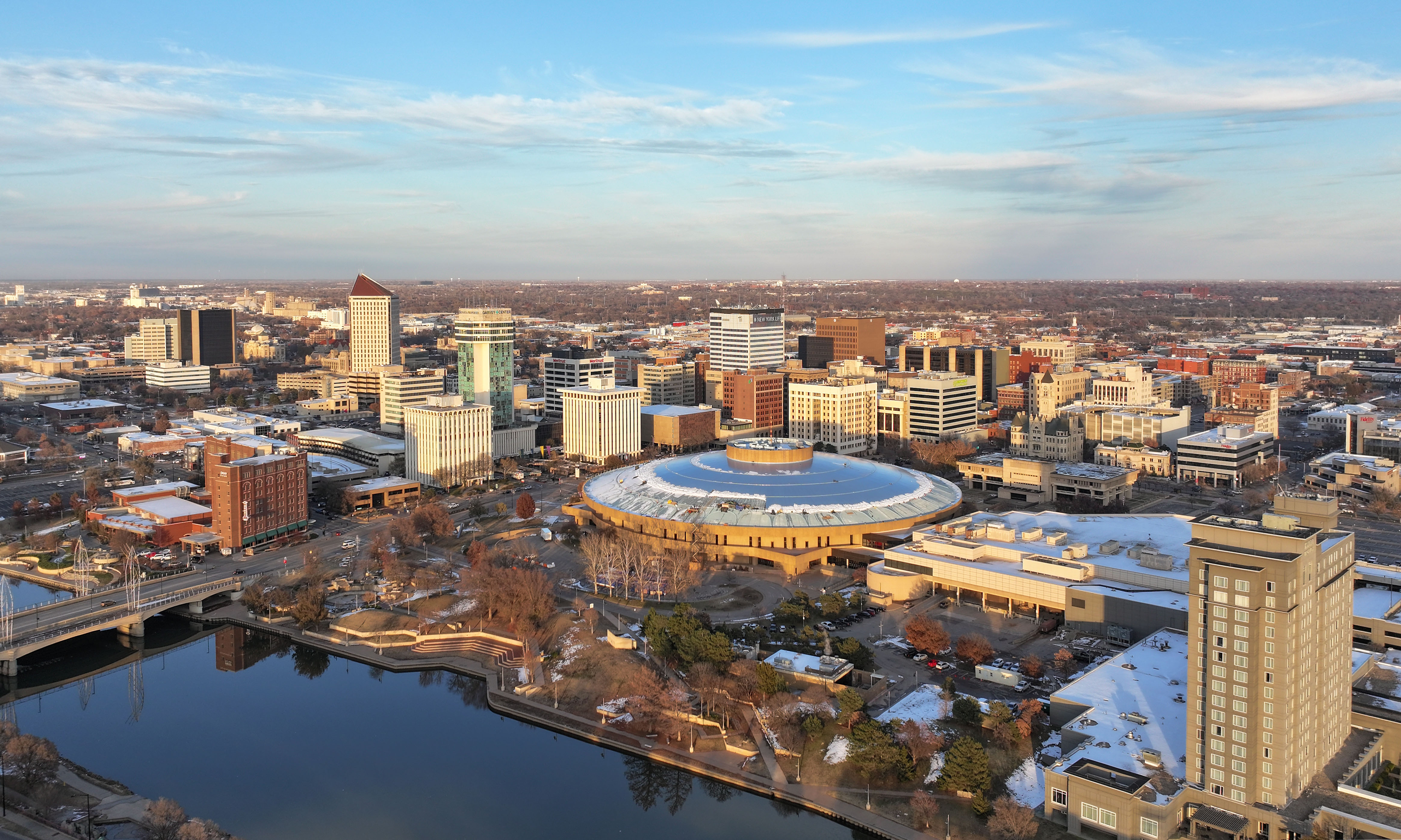 Aerial winter view of downtown Wichita skyline with a river in the foreground.