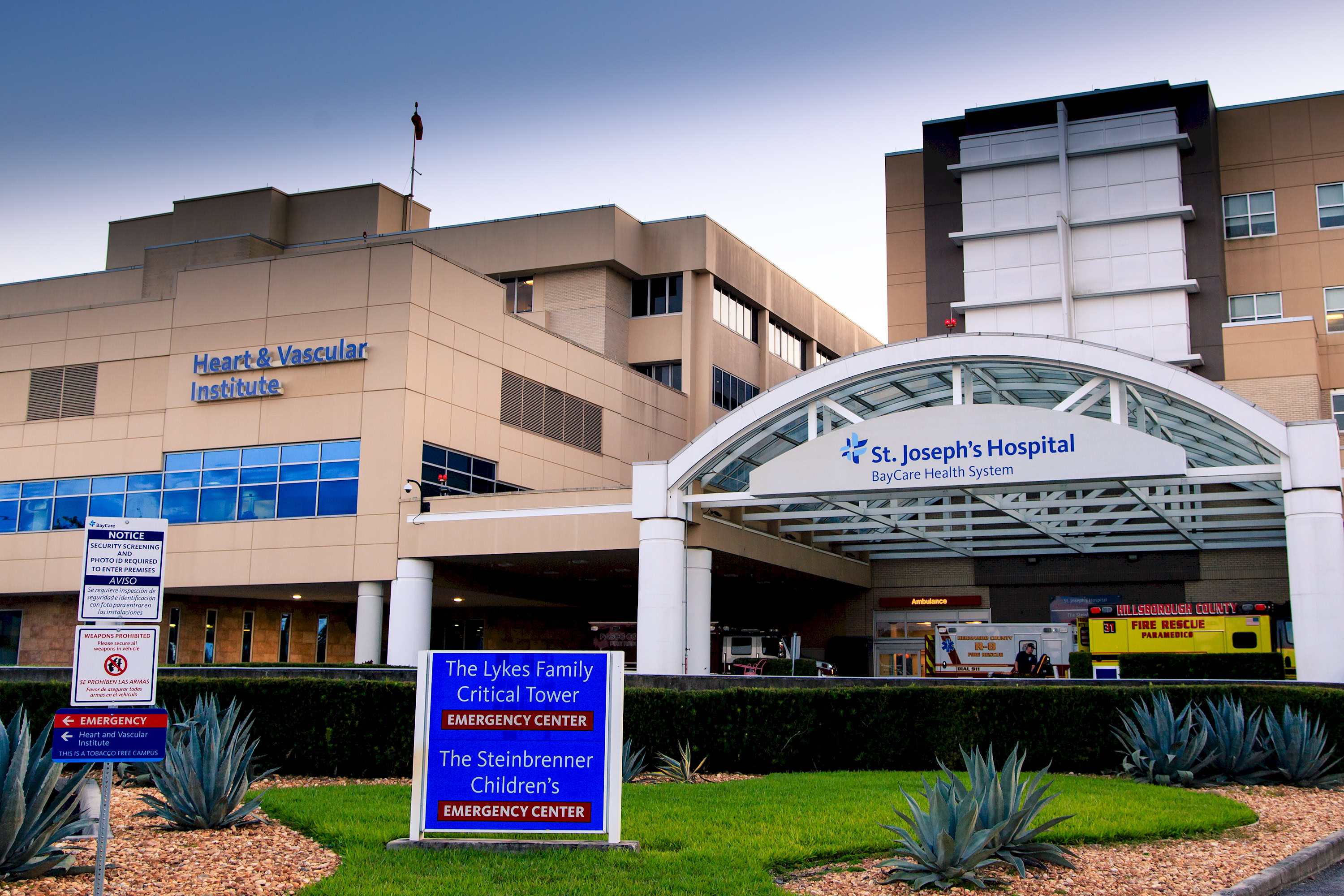 Exterior entrance of a hospital emergency center with covered ambulance bay.