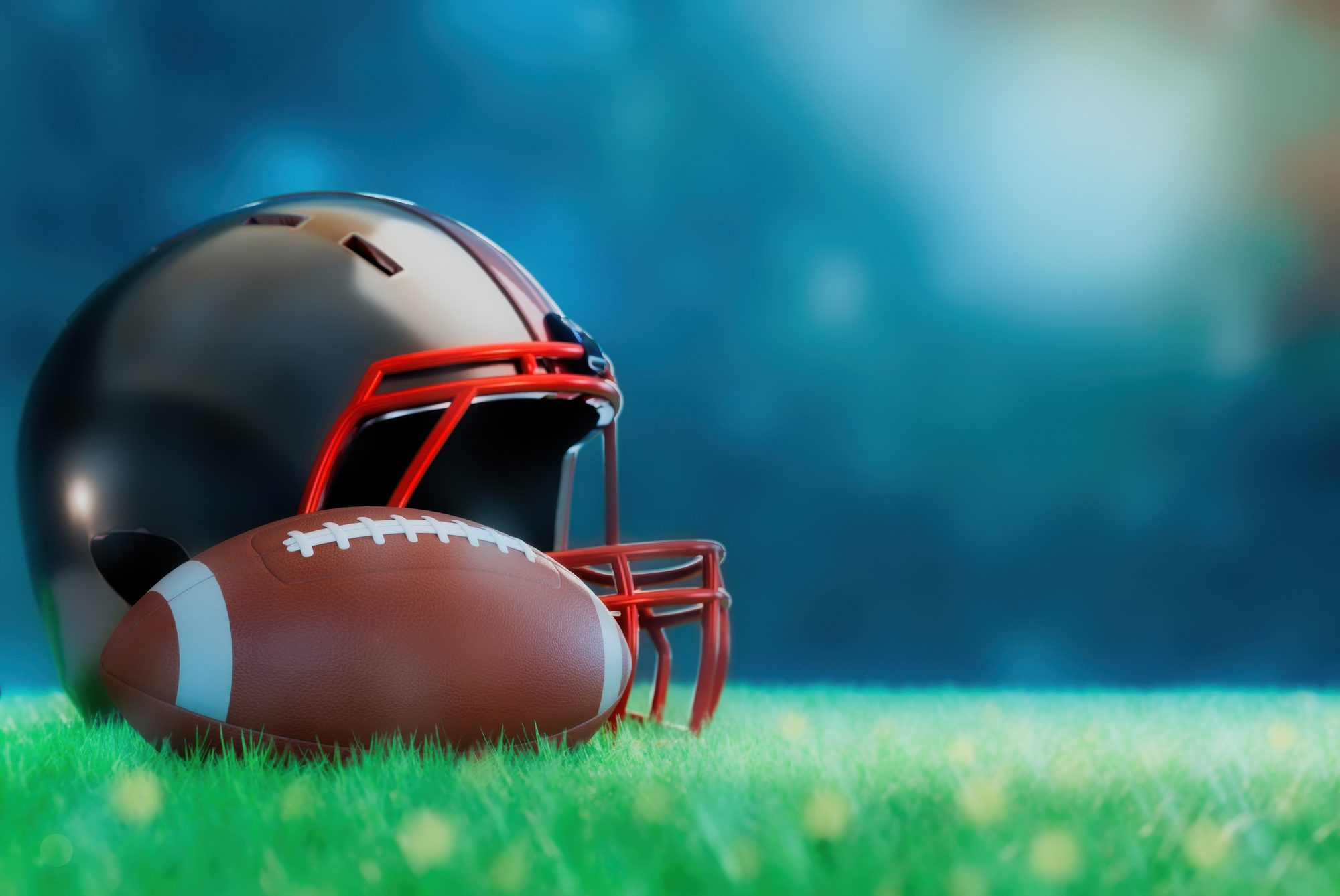 The football helmet and ball are resting on a grassy field.