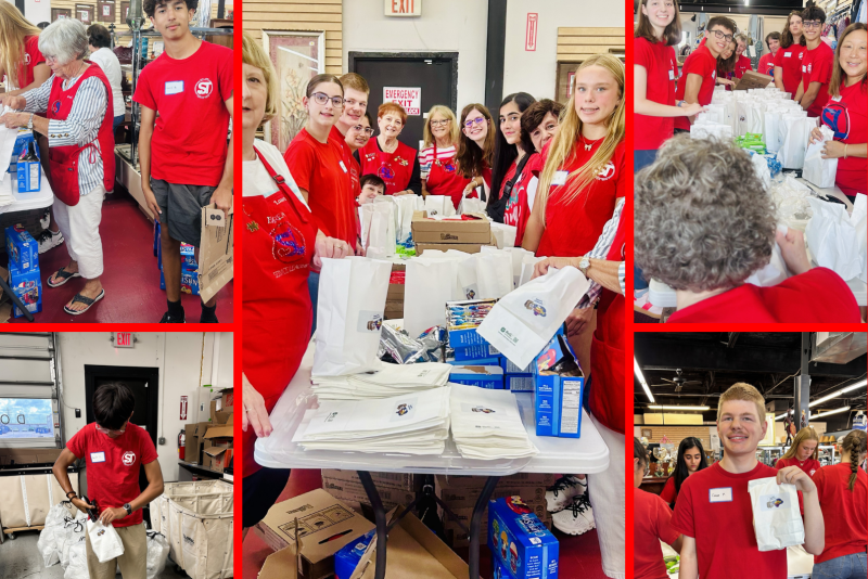 Teens and adults in red shirts pack bags and boxes at tables indoors.