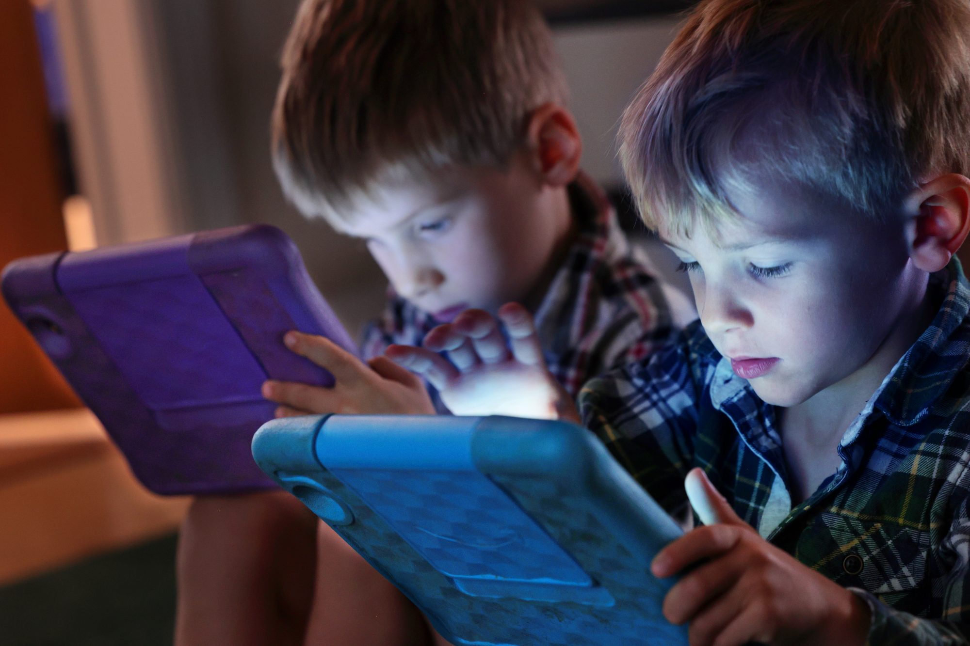 two young boys looking at computer tablets