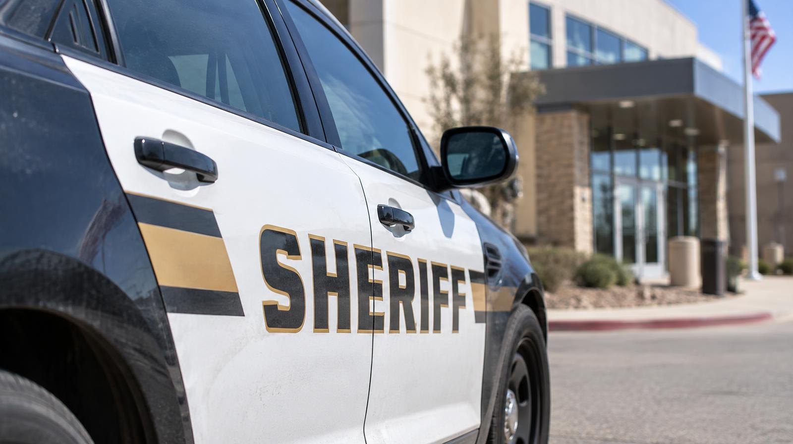 A sheriff's department patrol car parked outside a building.