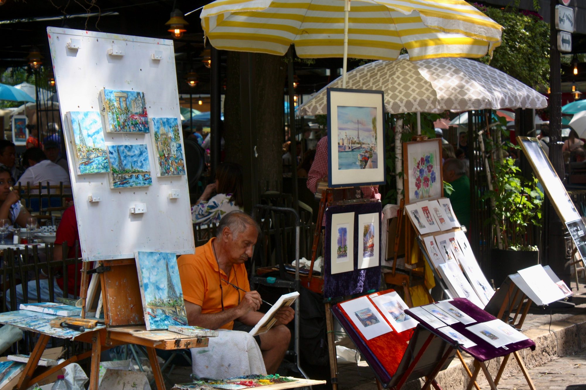 A vibrant art market scene in Montmartre, Paris showcasing a street artist painting outdoors.