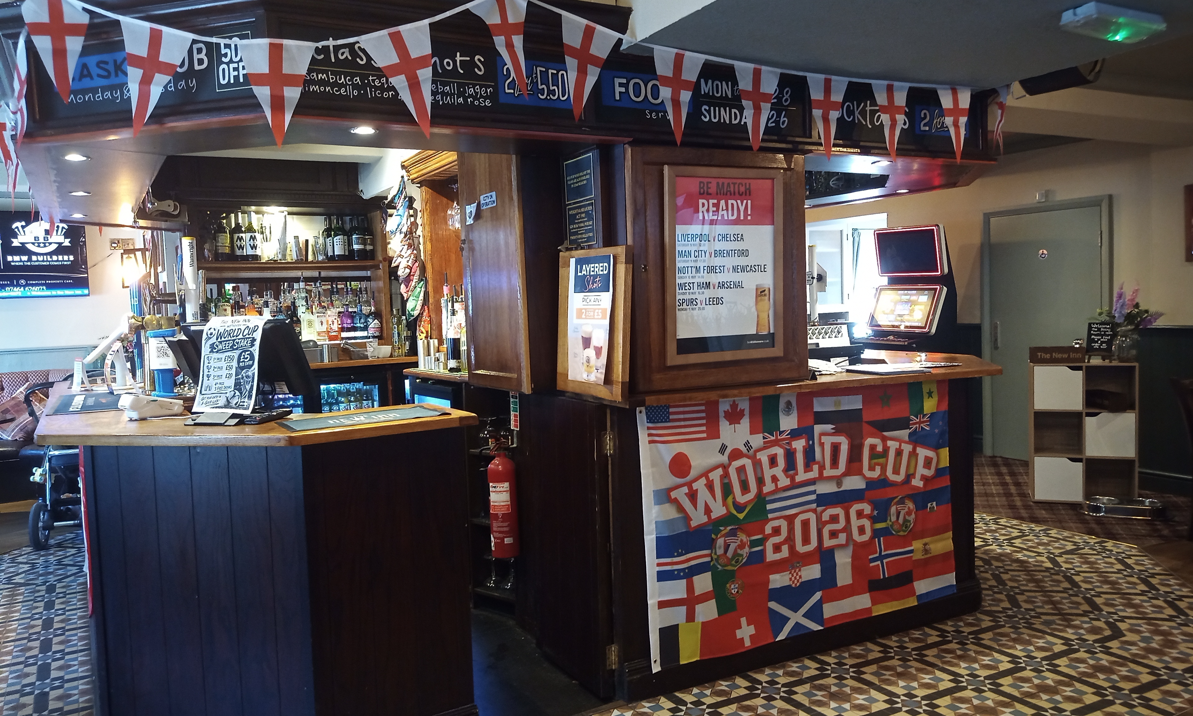 Pub bar front decorated with a World Cup 2026 banner and colorful international flags.