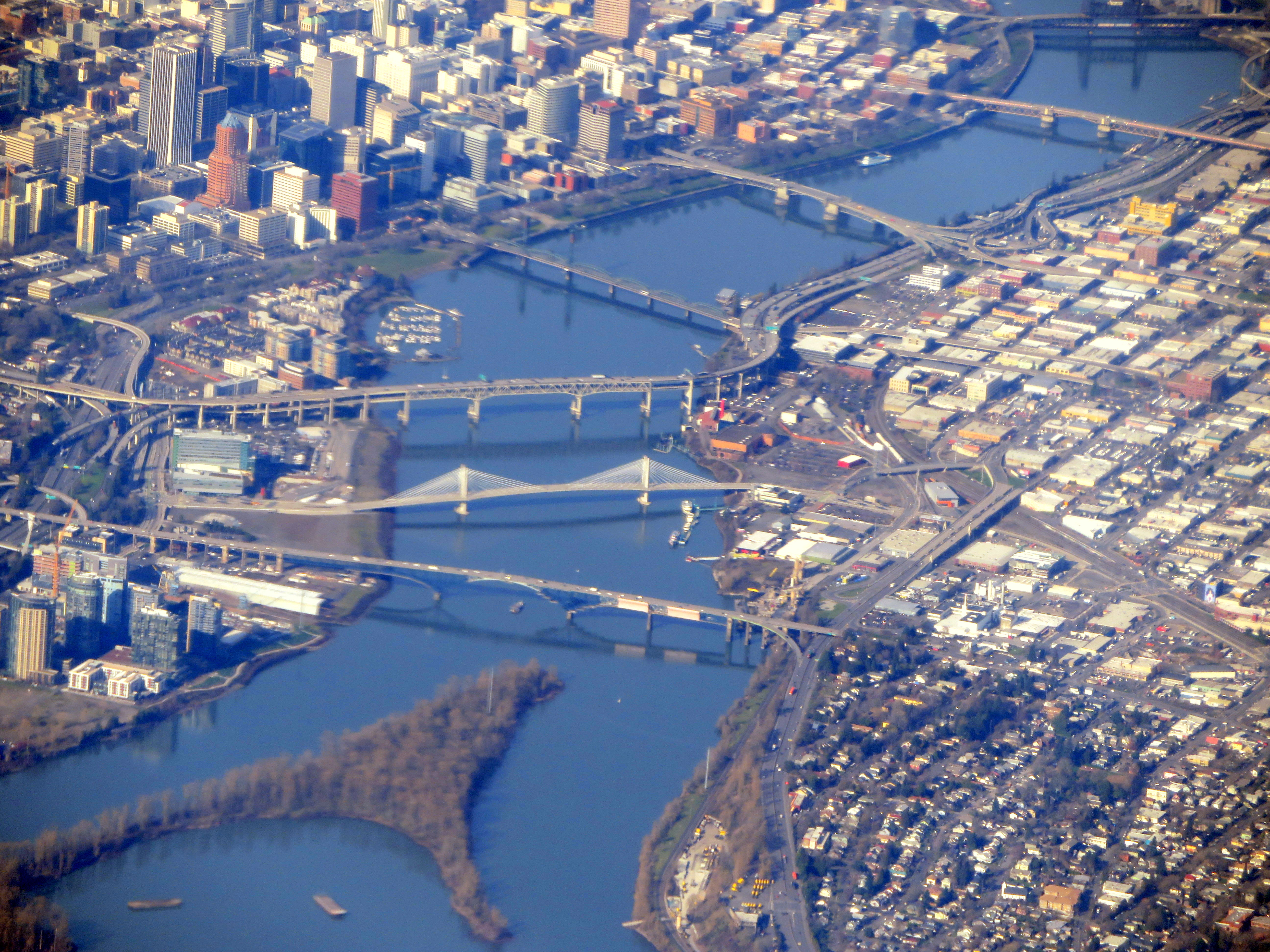 Aerial view of multiple bridges crossing a wide river through a city.