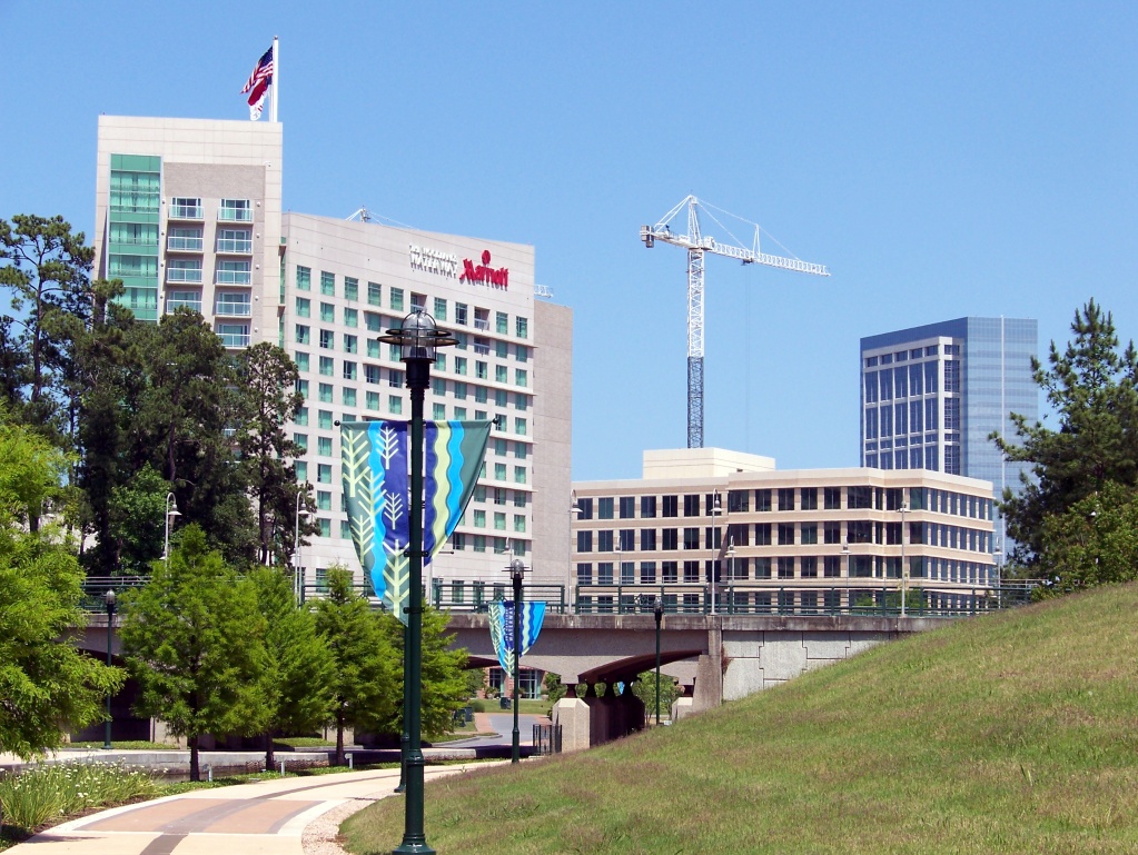 Exterior of The Woodlands Waterway Marriott hotel with a paved walkway and decorative banners.