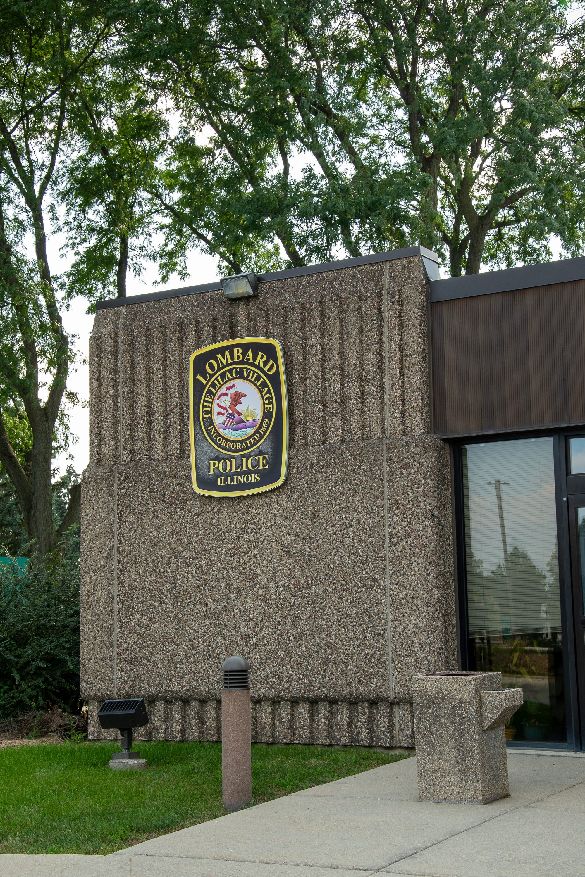Stone wall of a police department building bearing an official badge-style seal