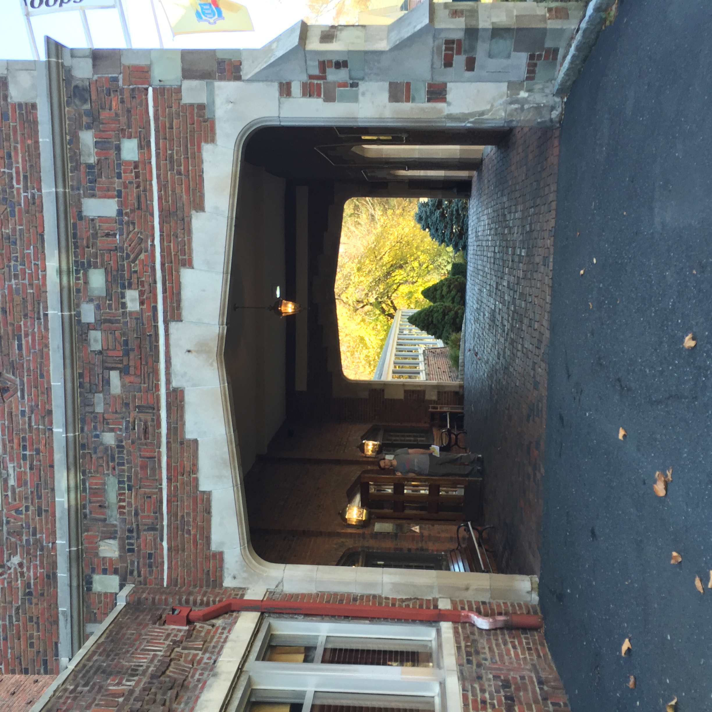 Brick archway entrance of a historic hotel with decorative masonry and hanging pendant lights.