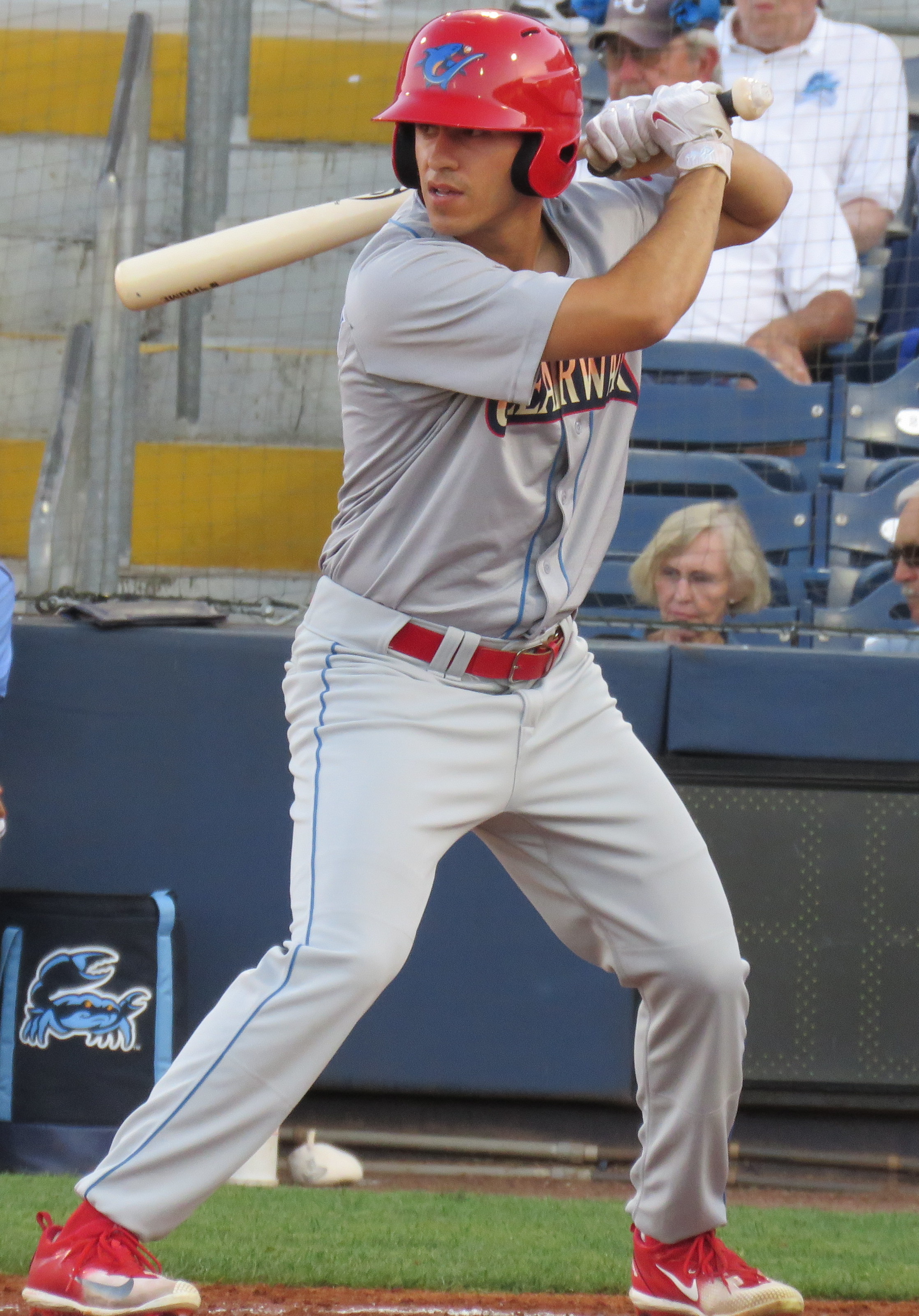 Baseball player in gray Clearwater Threshers uniform stands in a left-handed batting stance.