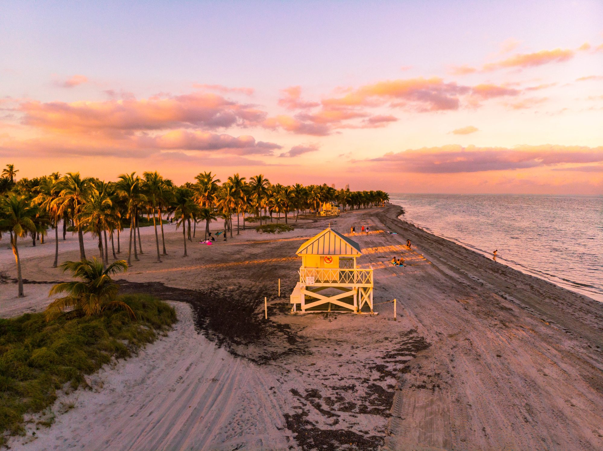 Drone view of the Key Biscayne beach with beautiful sunset and lifeguard hut.