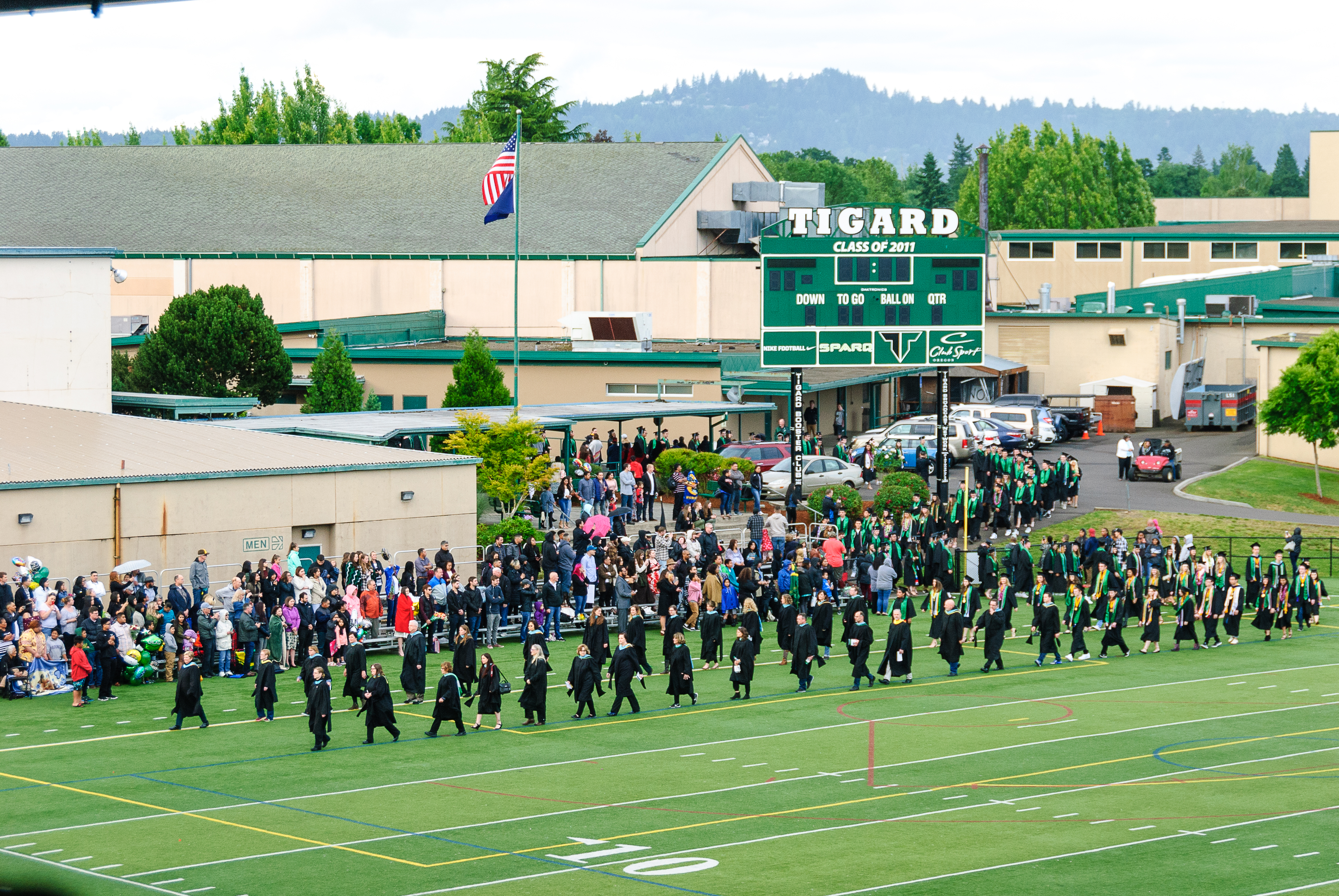 Aerial view of a high school football field with green turf and red end zones.