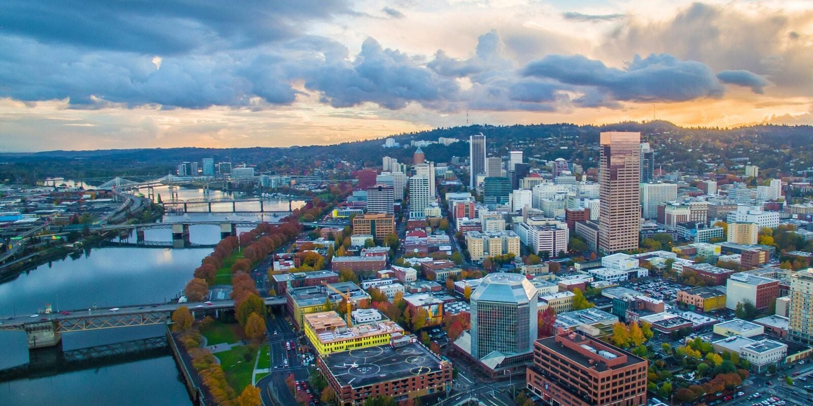 Aerial view of downtown Portland with the Willamette River and bridges at dusk.