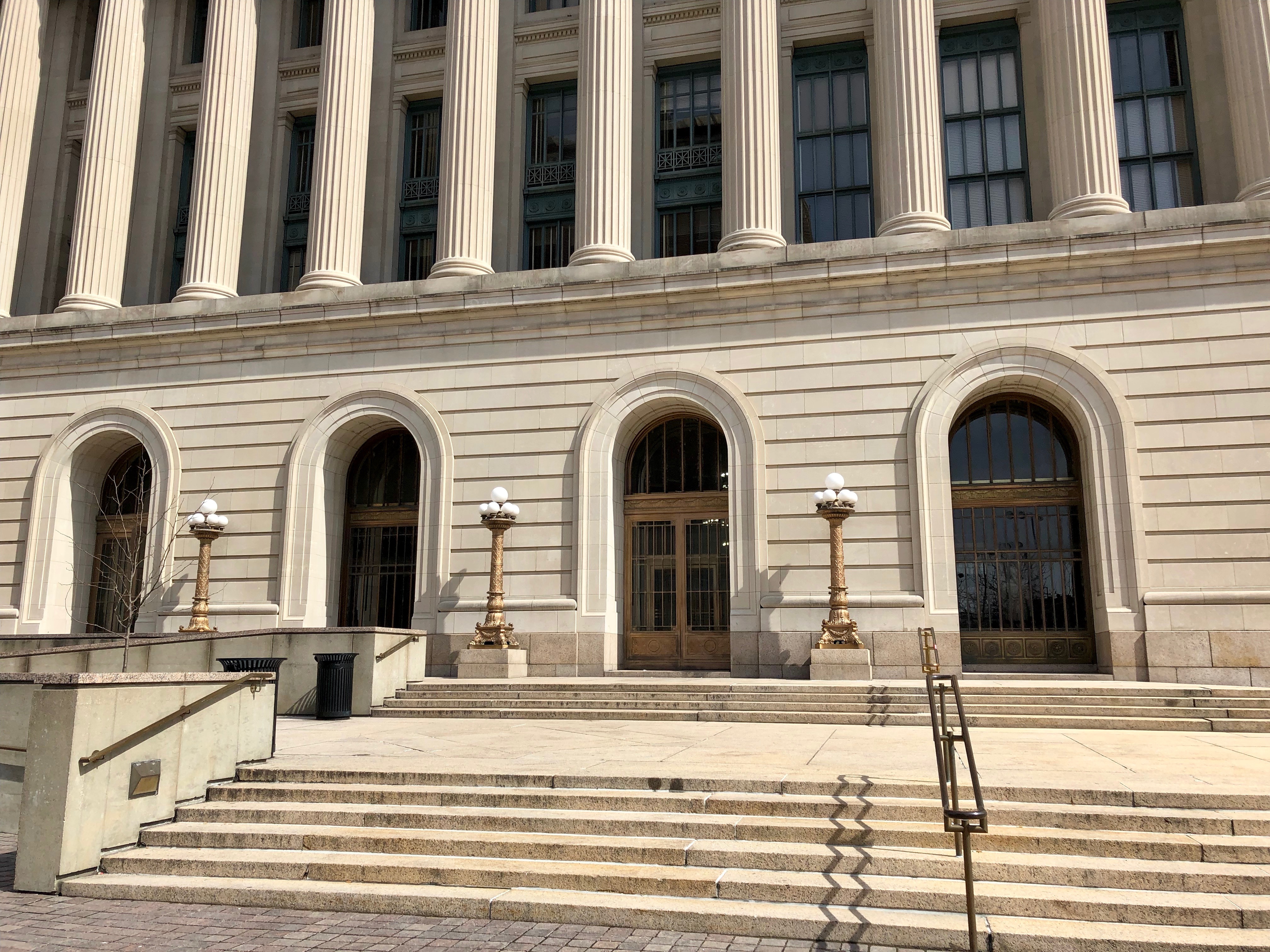 Stone steps and ornate columns at the entrance of a neoclassical courthouse building.