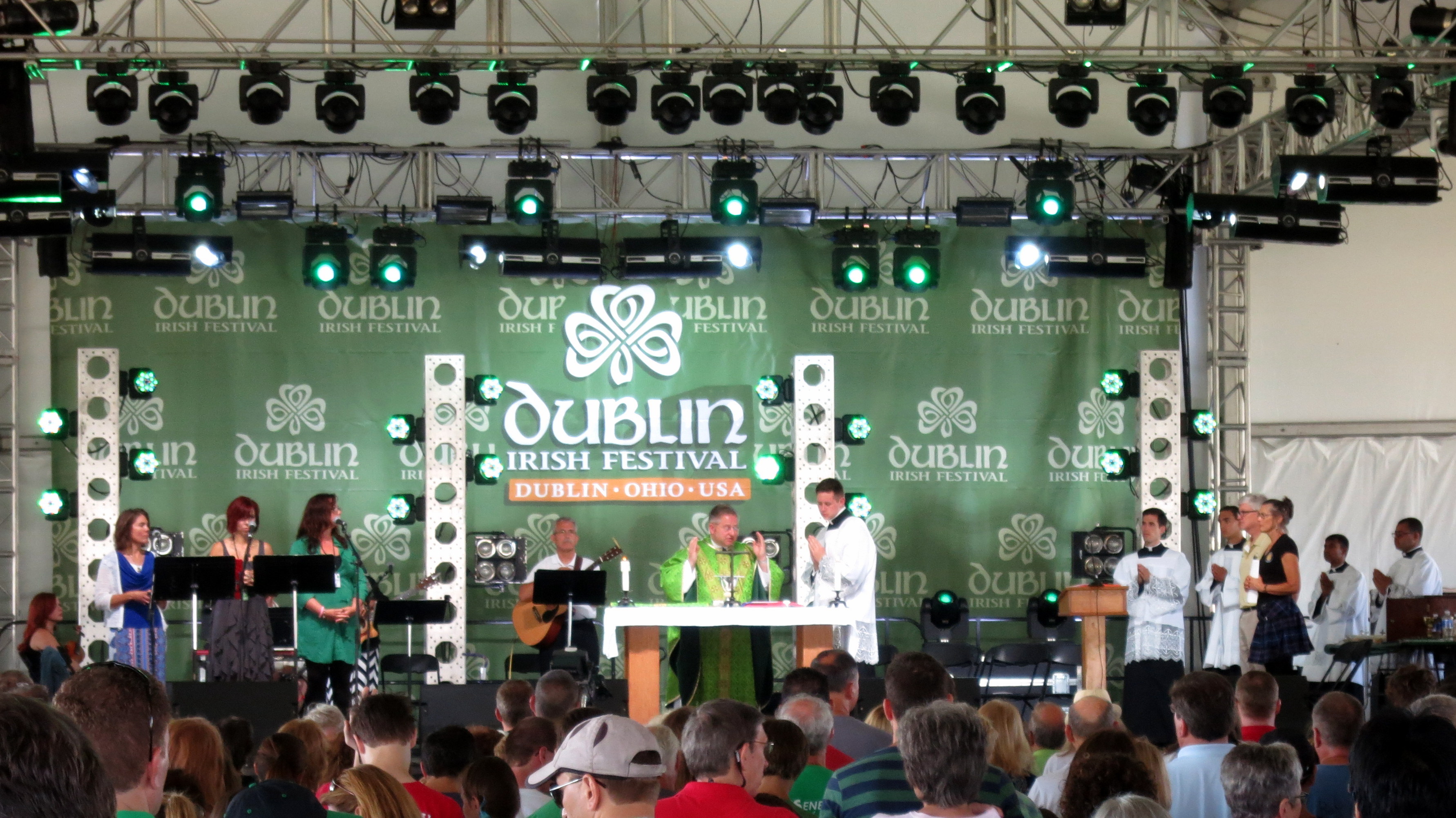 A large crowd watches a stage performance at an outdoor Irish festival.