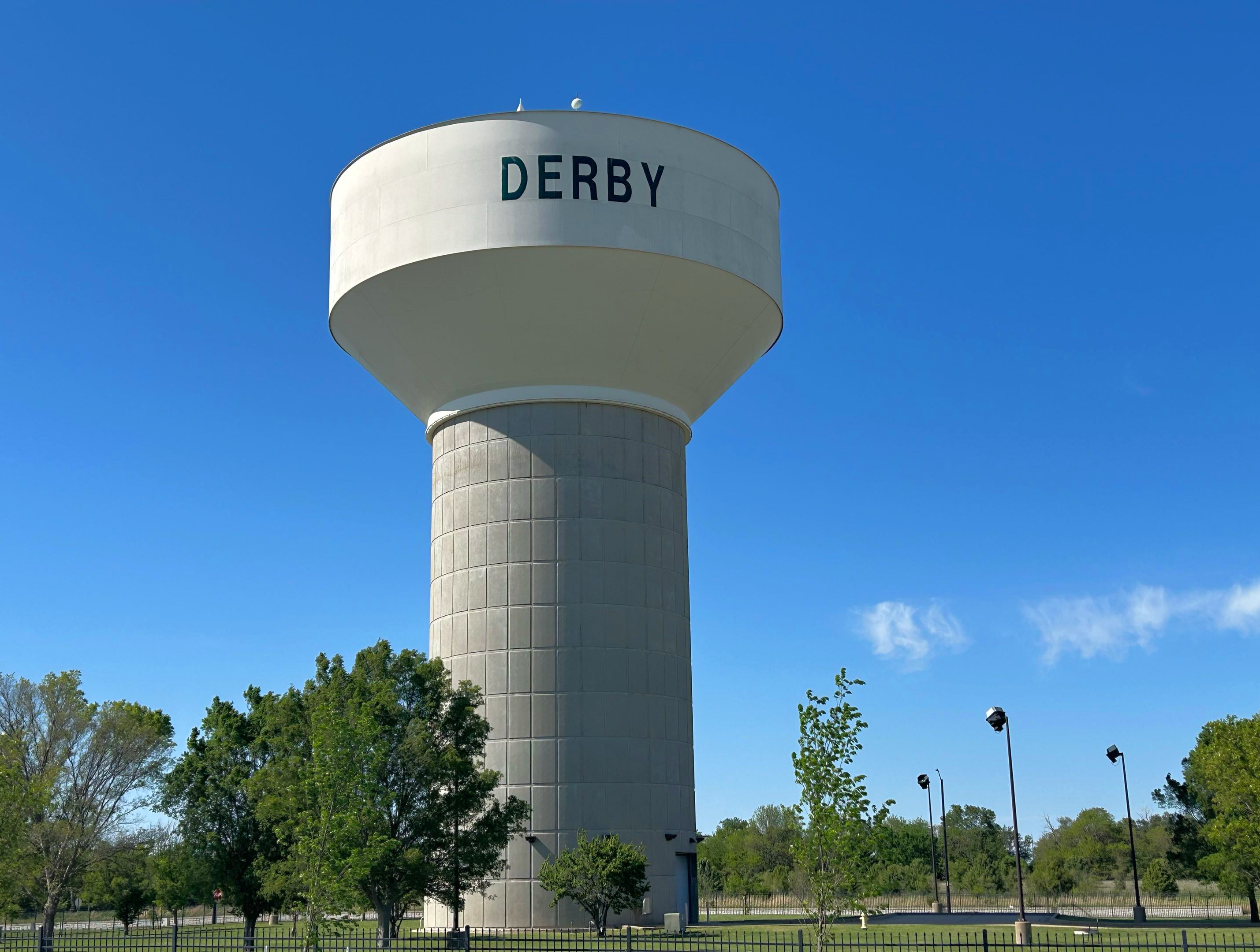 Tall concrete municipal water tower against a clear blue sky.