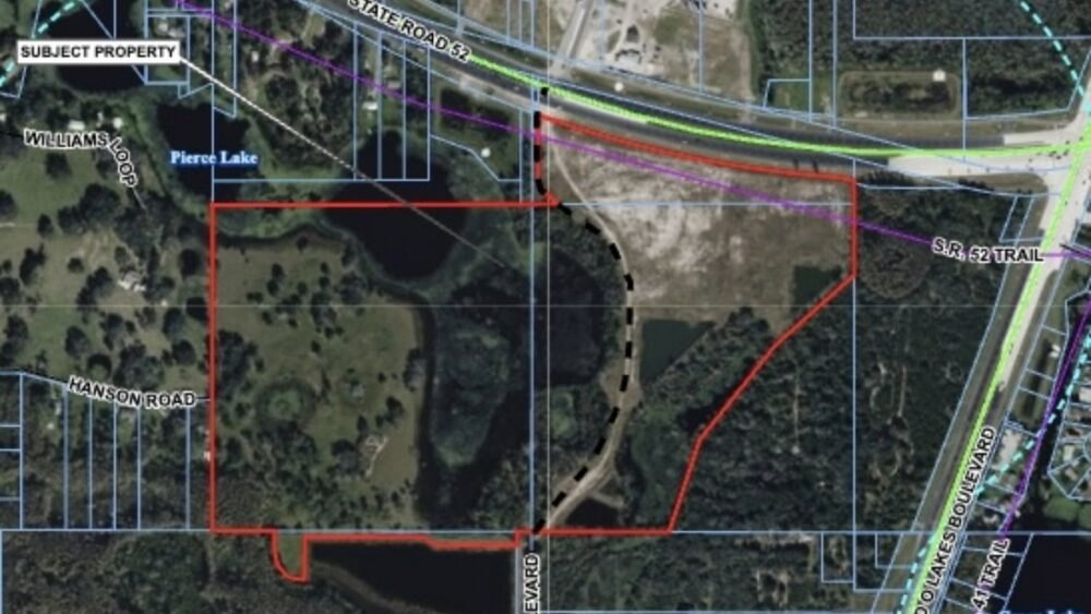 Aerial satellite map with a red boundary outlining a large undeveloped land parcel near State Road 52.