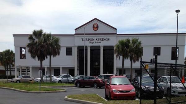 Exterior of a school administration building with palm trees and a parking lot.