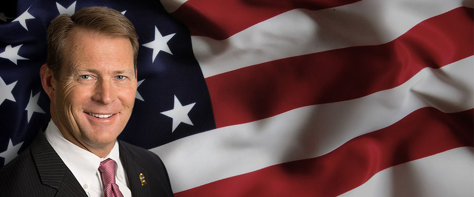 Doug Lloyd behind an American Flag.