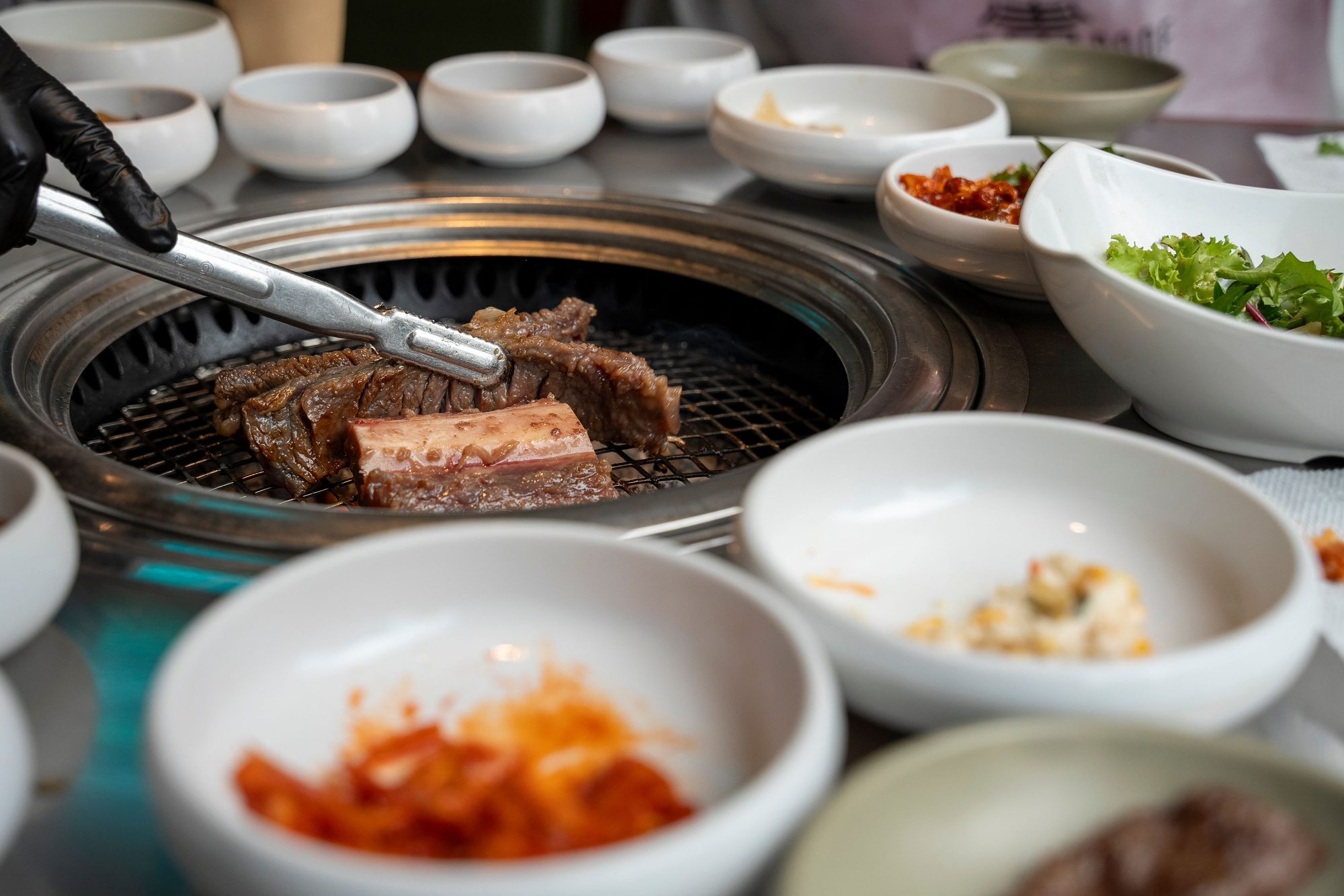 Traditional Korean BBQ grilling with assorted side dishes in Seoul, South Korea.