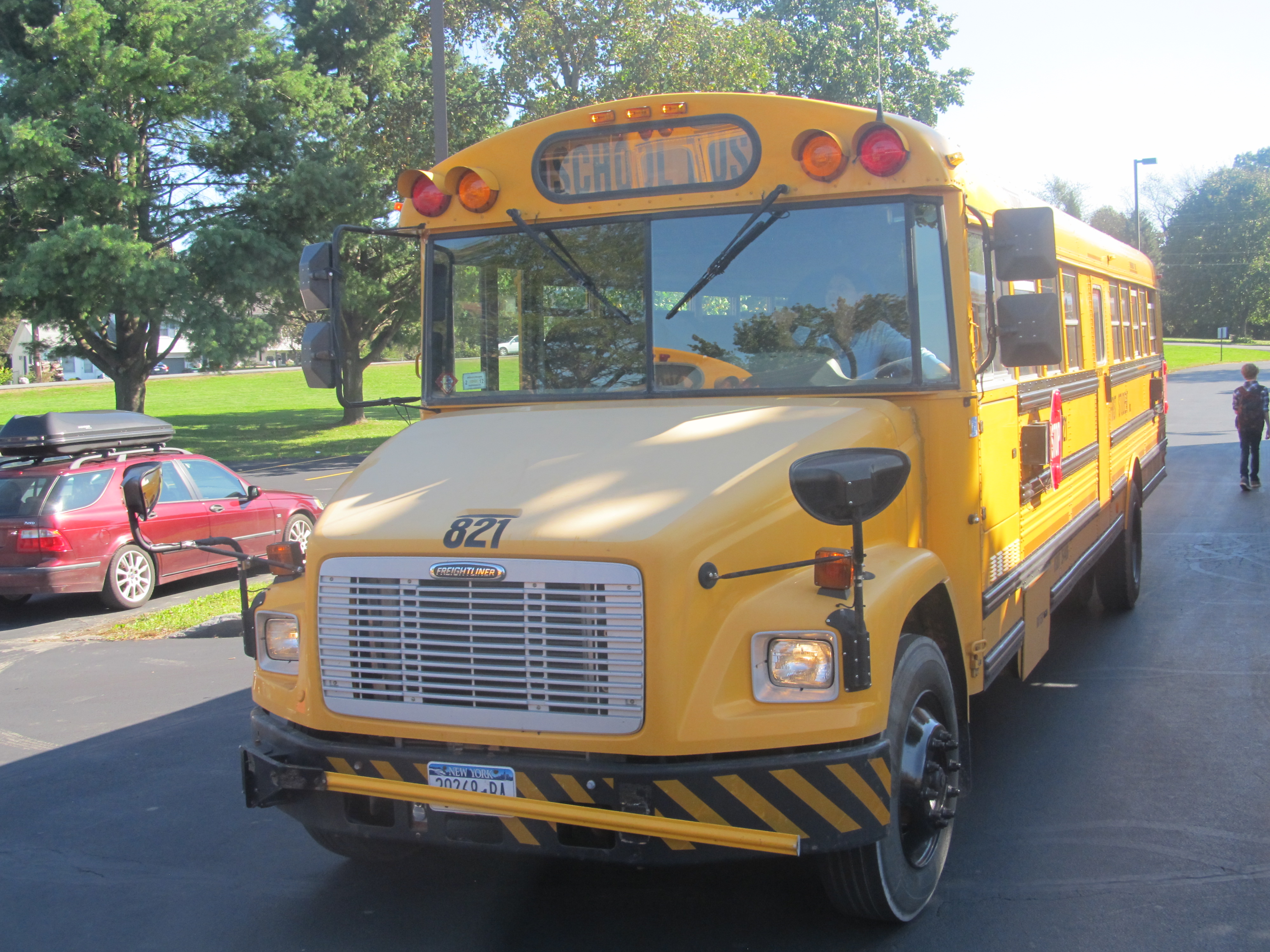 A yellow school bus photographed head-on in a parking lot.