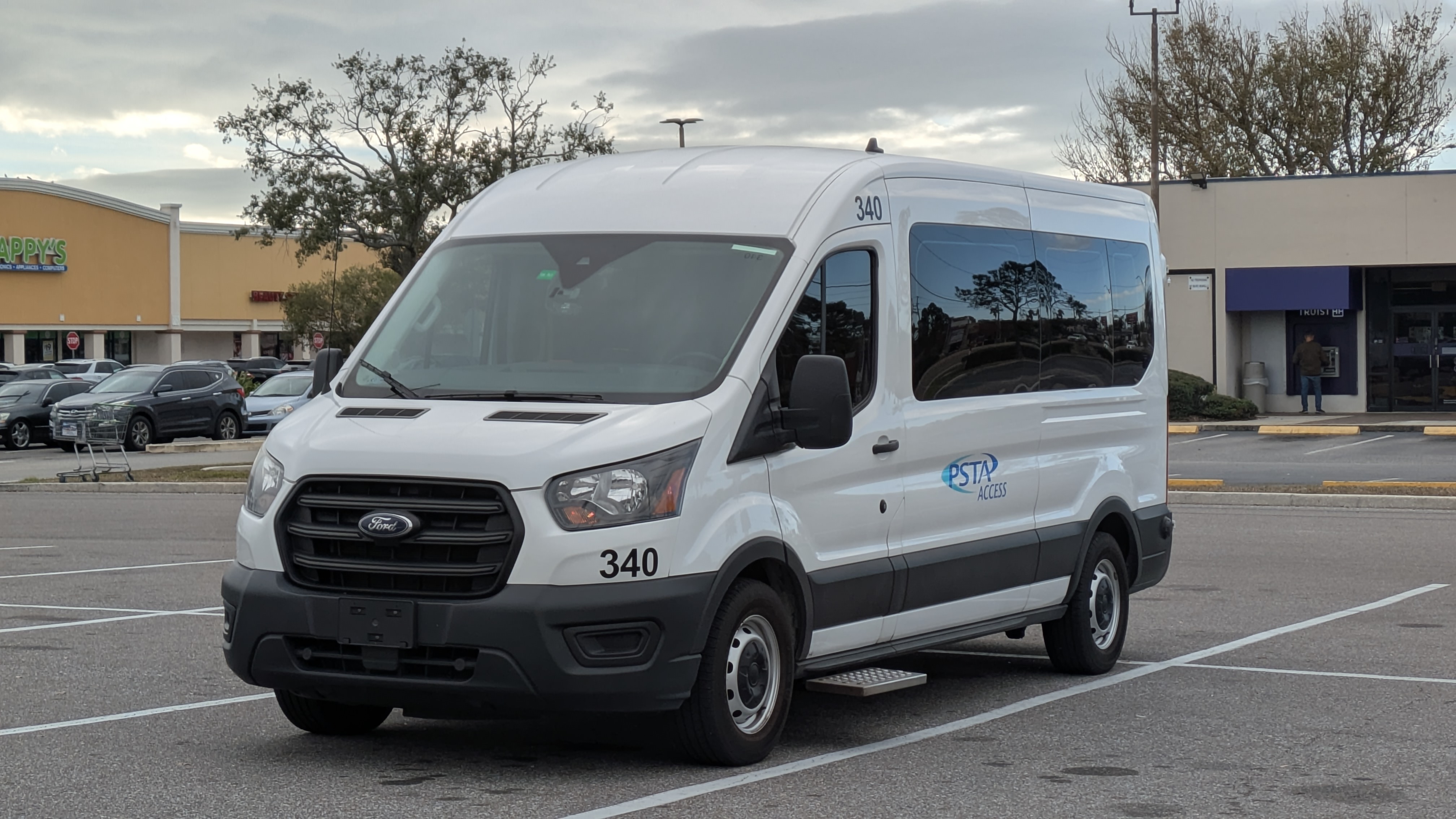 White PSTA-branded Ford Transit van parked in a commercial parking lot