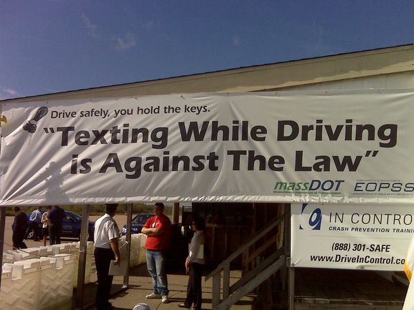 Large outdoor banner warning that texting while driving is against the law.