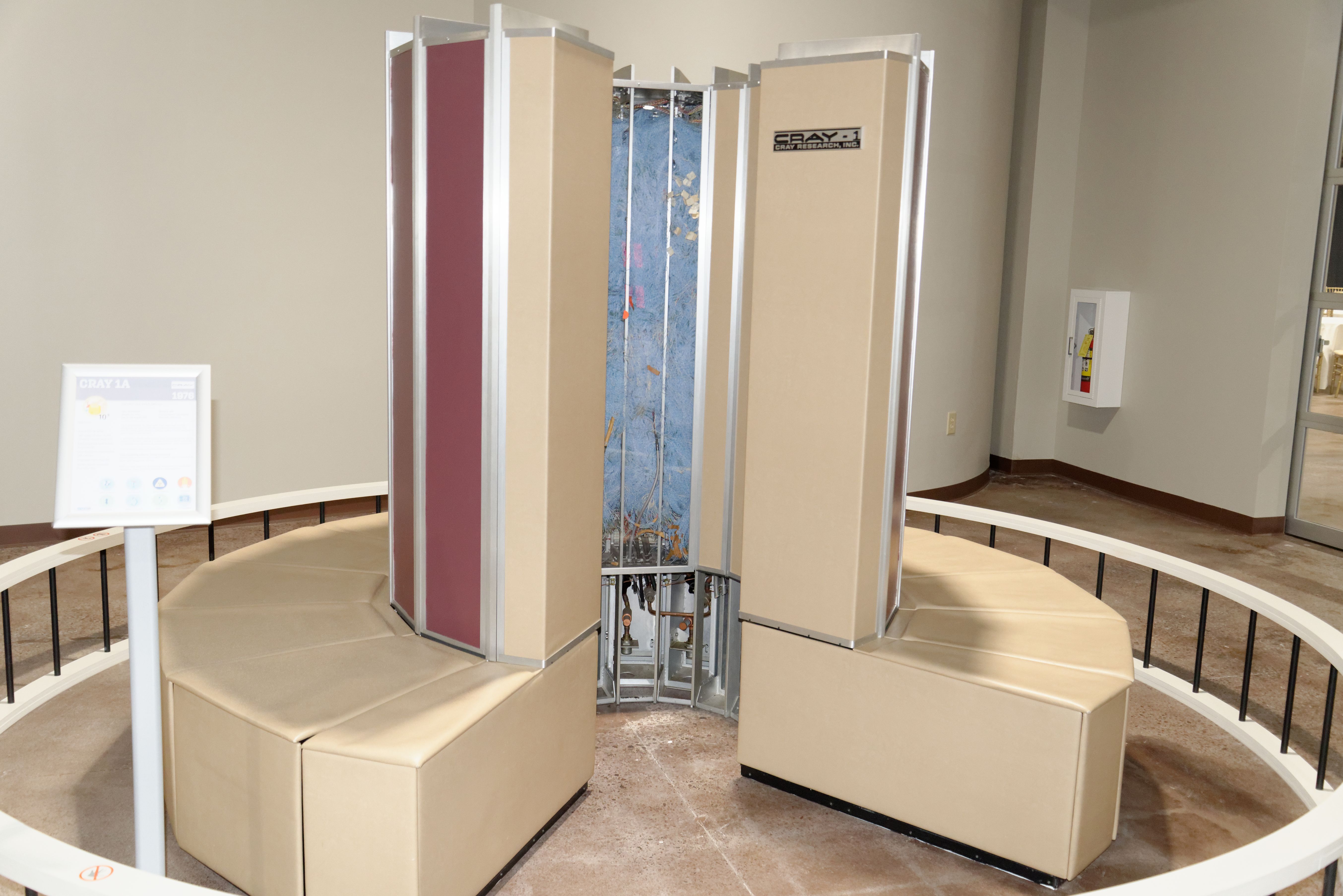 Cray-1 supercomputer with curved bench seating on display in a museum gallery.
