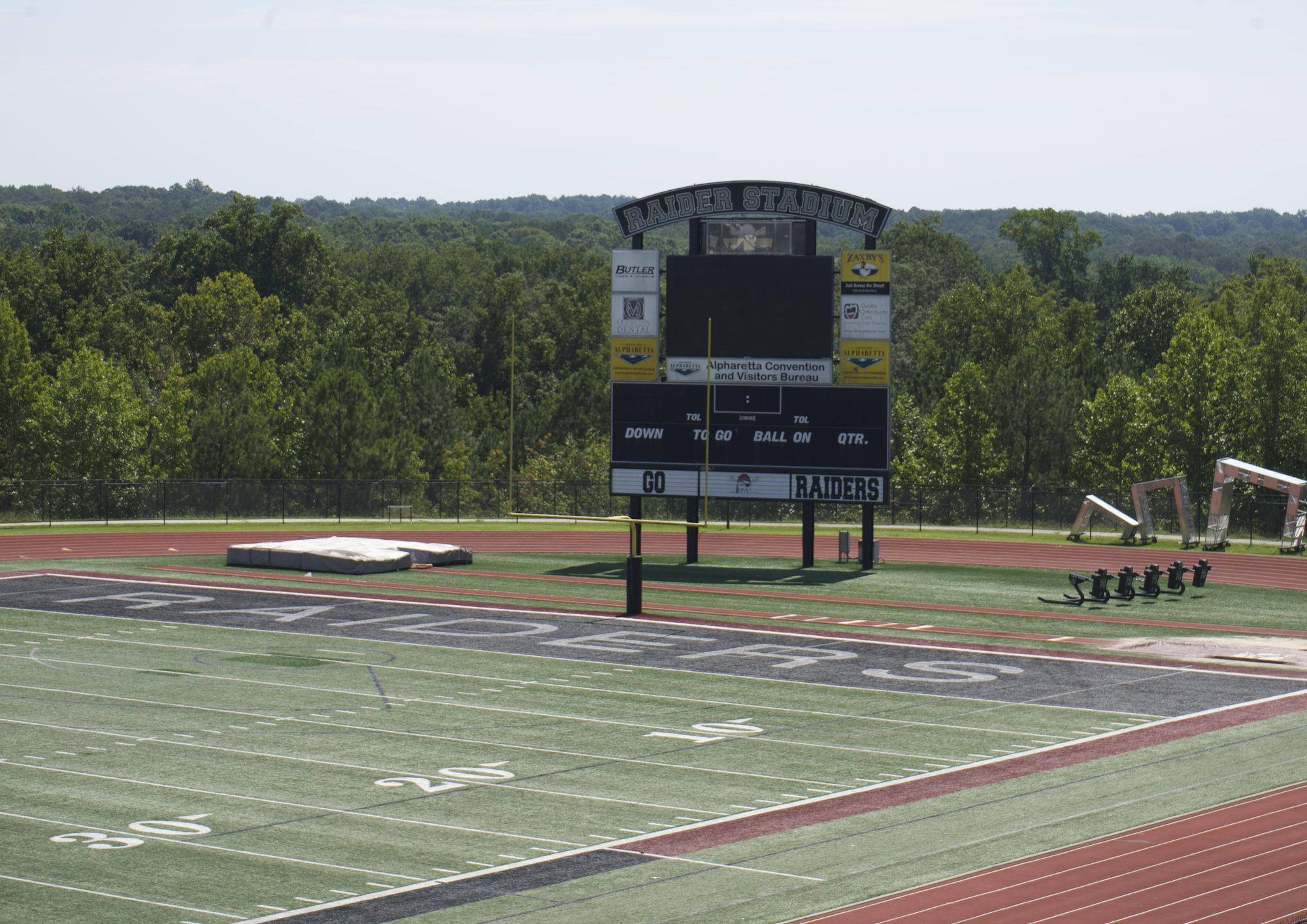 High school football stadium scoreboard at the end of an artificial turf field