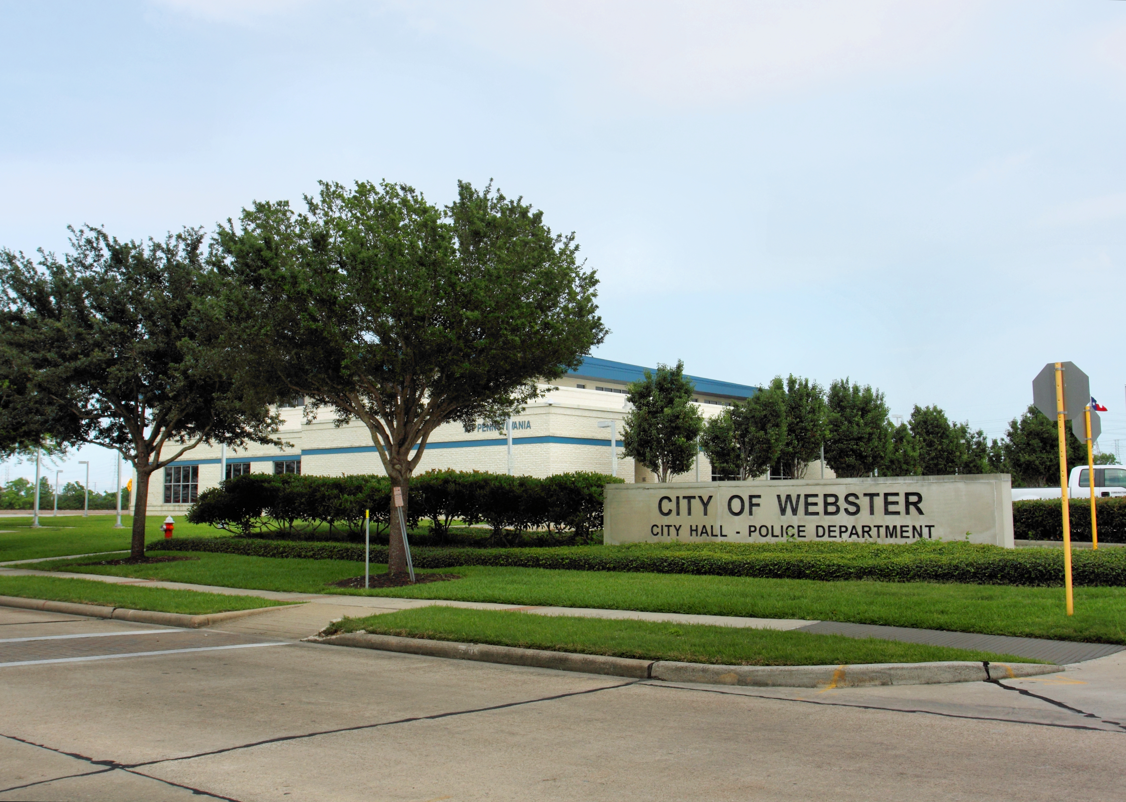 Exterior of a municipal building with a stone sign reading City of Webster City Hall Police Department.