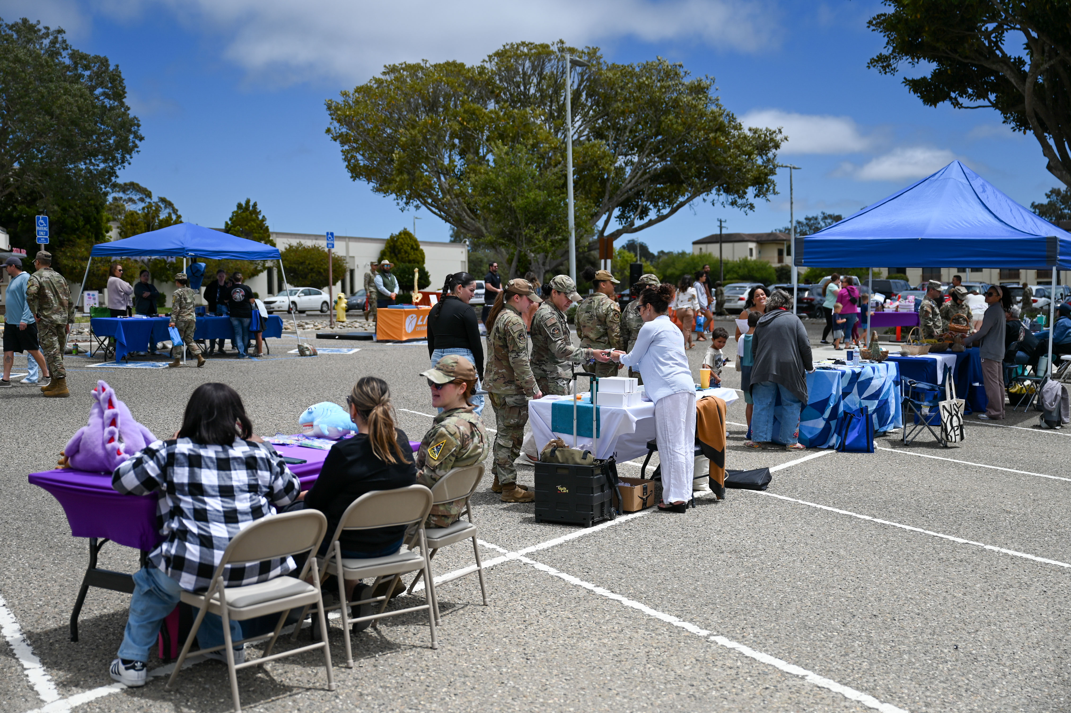 Rows of blue canopy tents and vendor tables at an outdoor health fair.