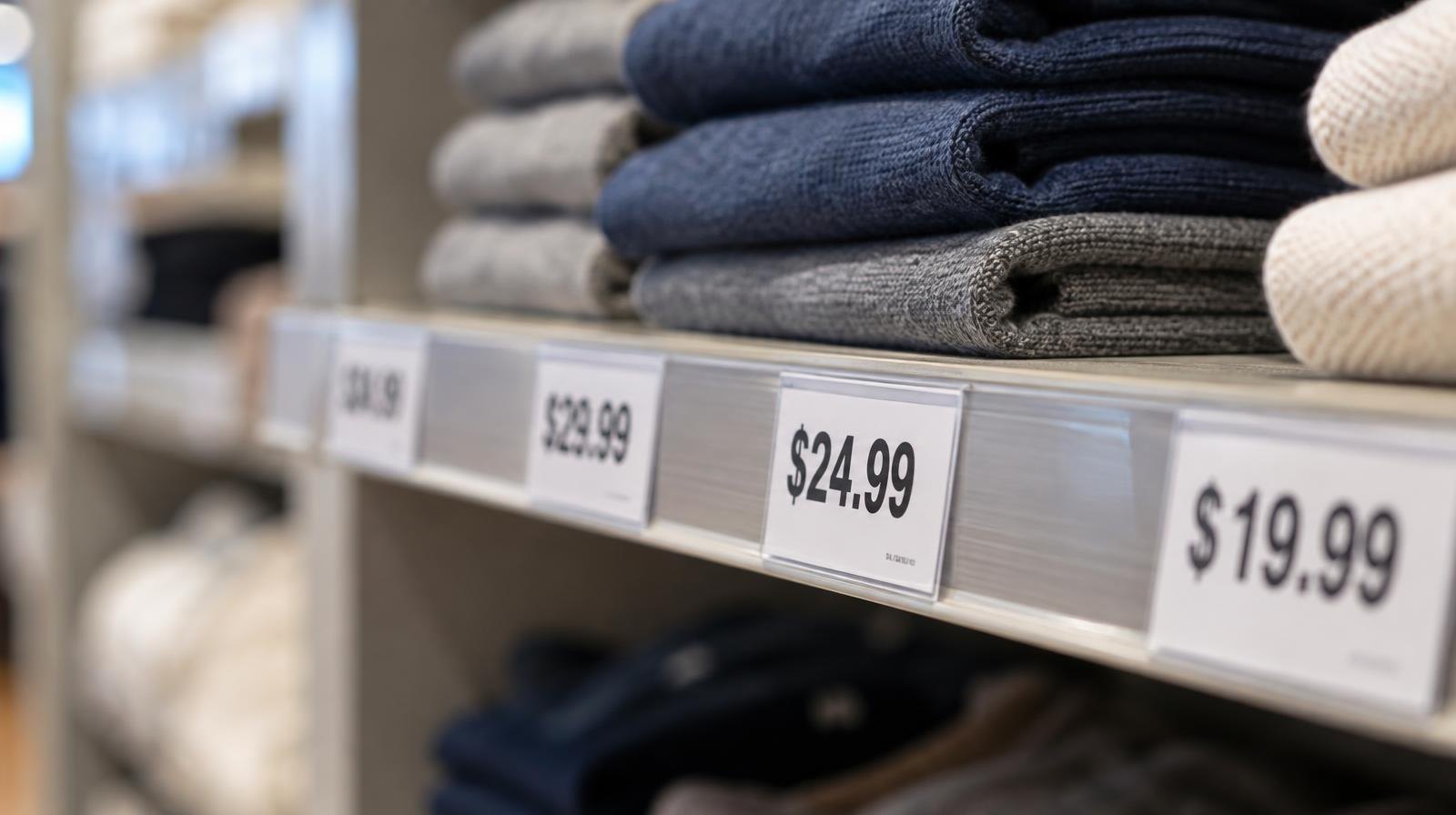Close-up of price tags attached to retail merchandise on a store shelf.